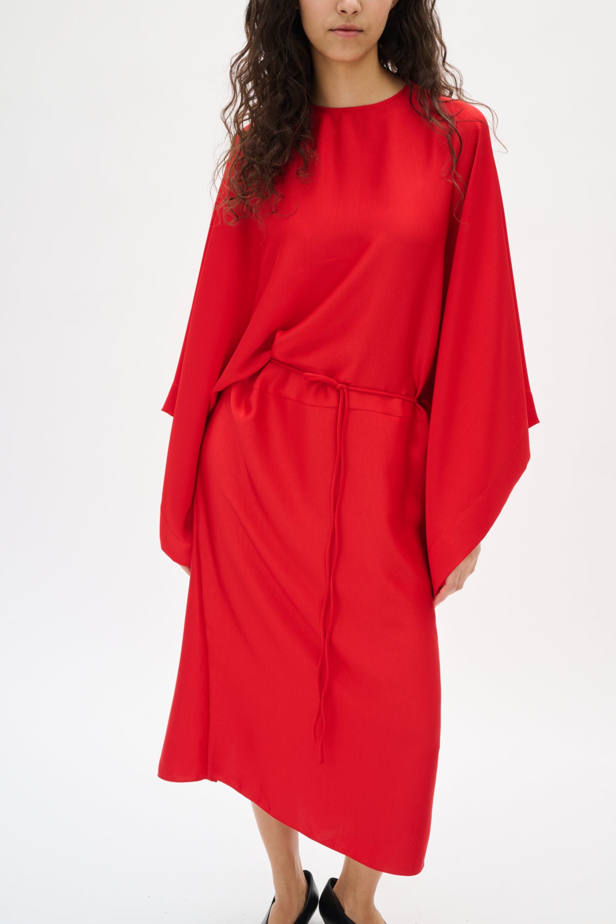 Red dress worn by a model on a white background