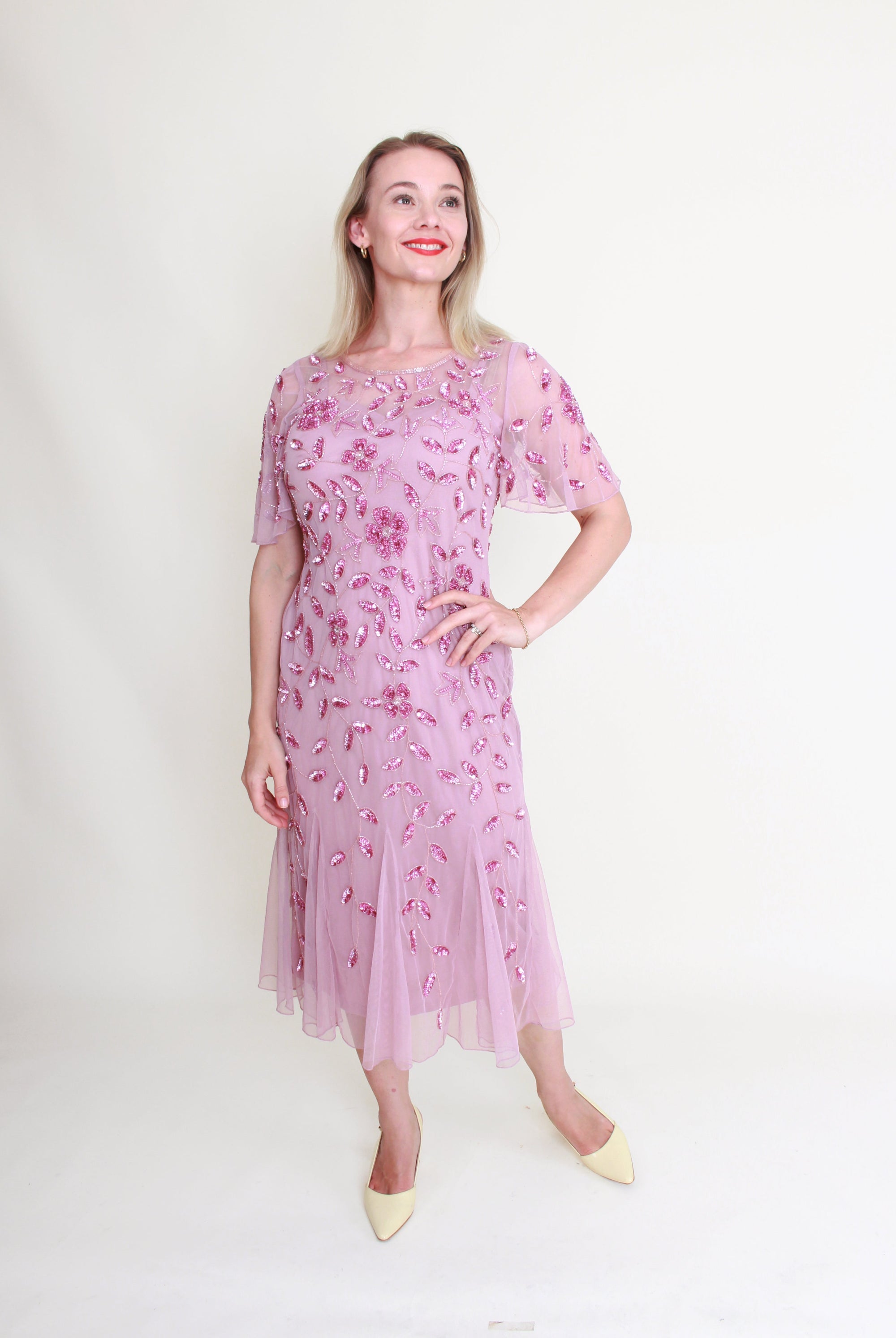 Woman wearing a pink floral dress against a white background