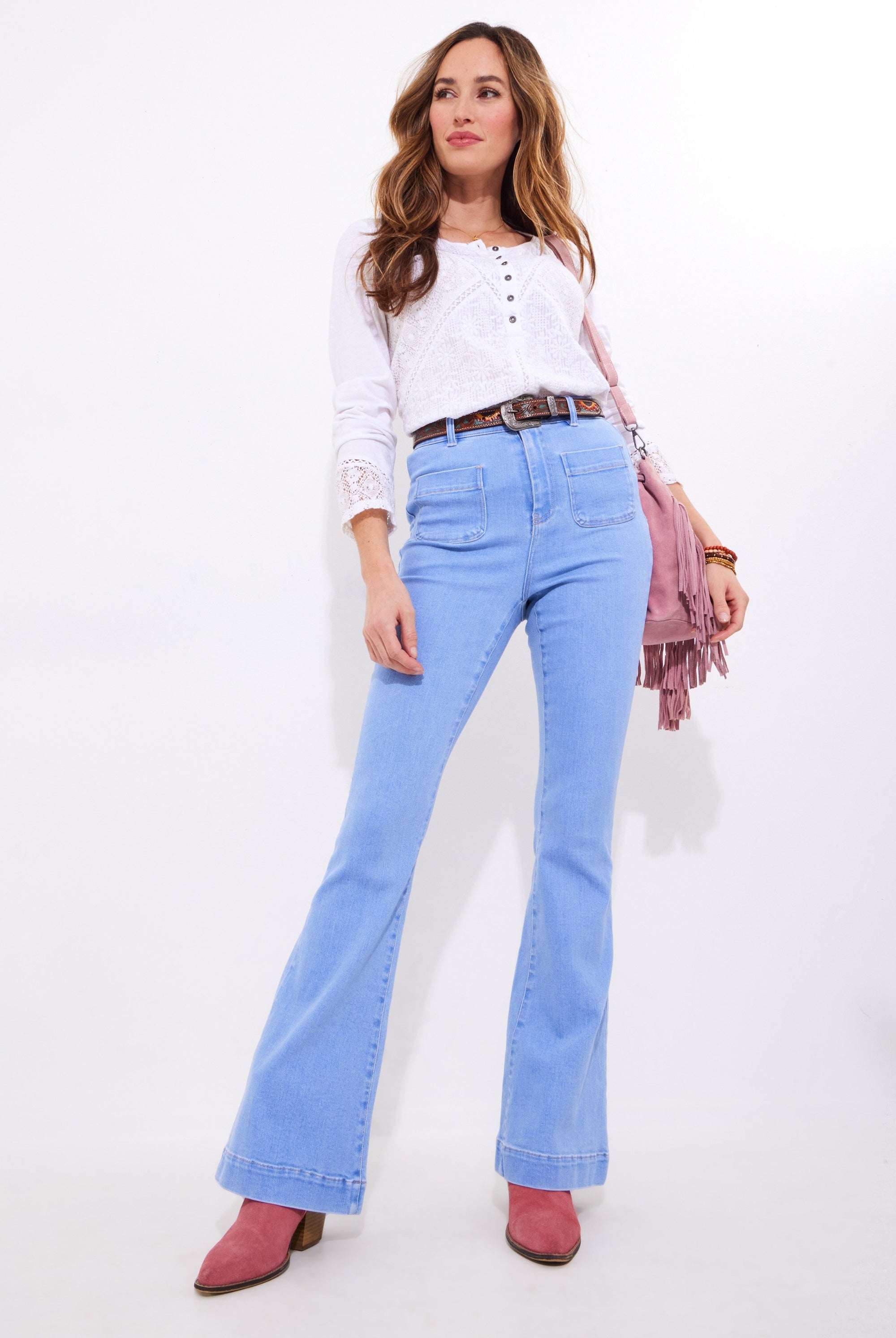light wash denim flare jean and white blouse worn by model
