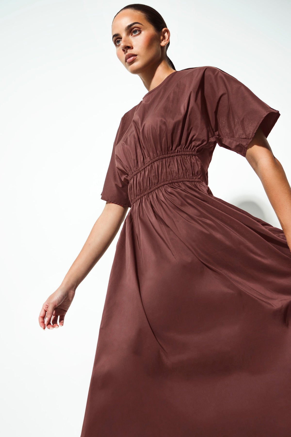 women wearing a brown dress gathered at the waist on a white background