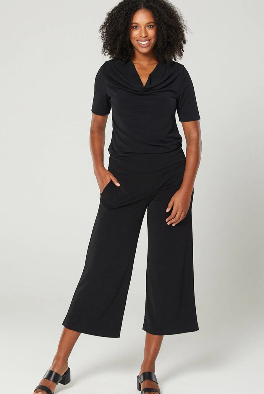 Woman wearing a black jumpsuit on a white background