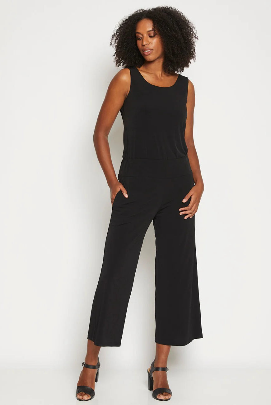 Woman wearing a black sleeveless jumpsuit on a white background