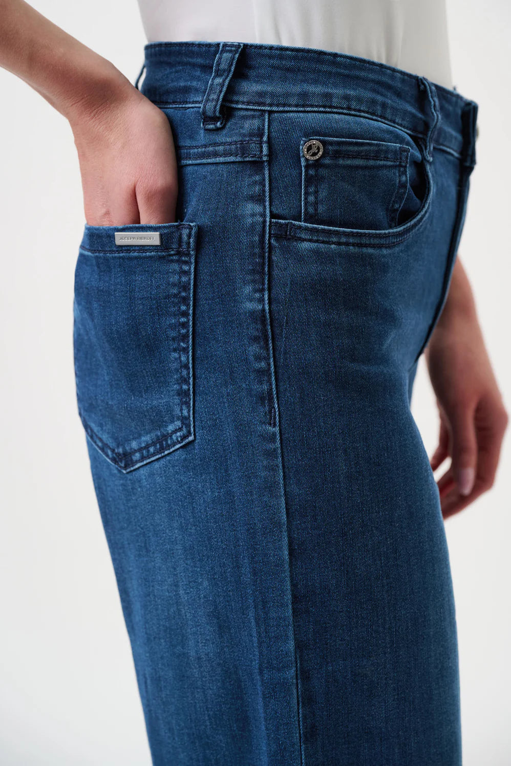 Blue jeans worn by a person on a white background