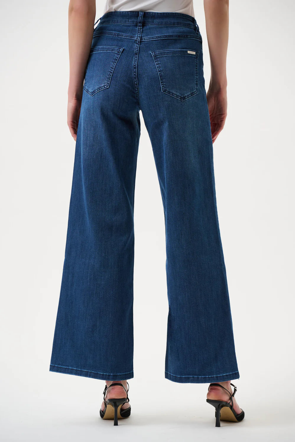 Blue jeans worn by a person on a white background back angle