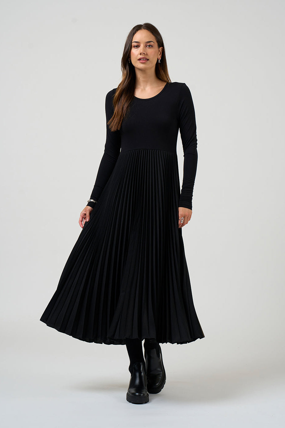 Woman wearing a black pleated dress on a white background