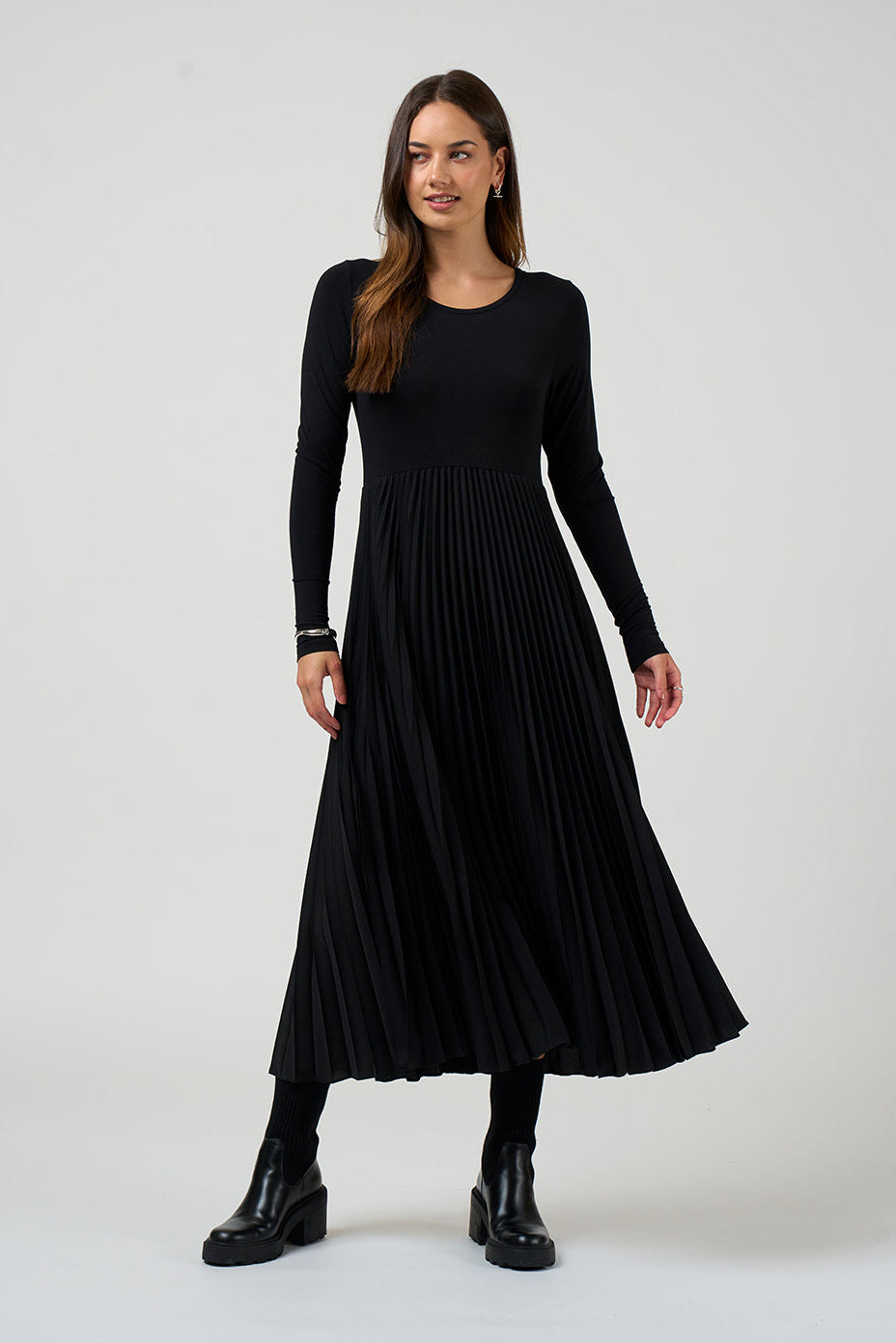 Woman wearing a black pleated dress on a white background