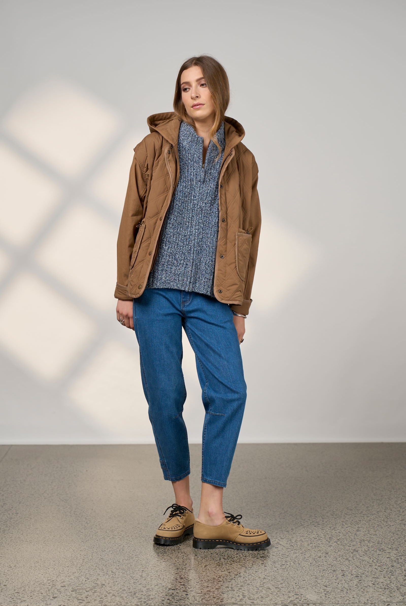 women wearing blue jeans and a brown jacket