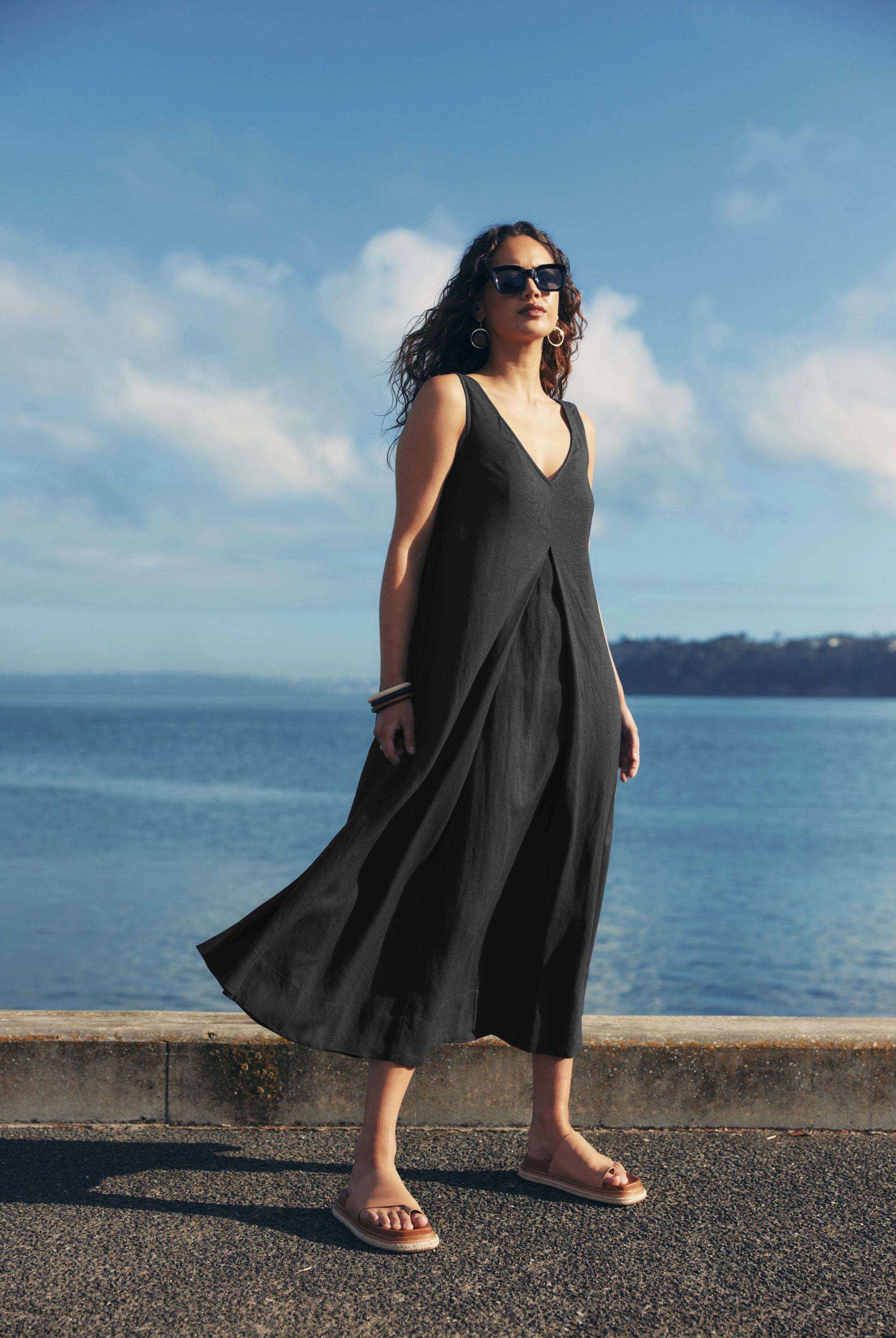 pleat maxi dress black worn by model ocean background