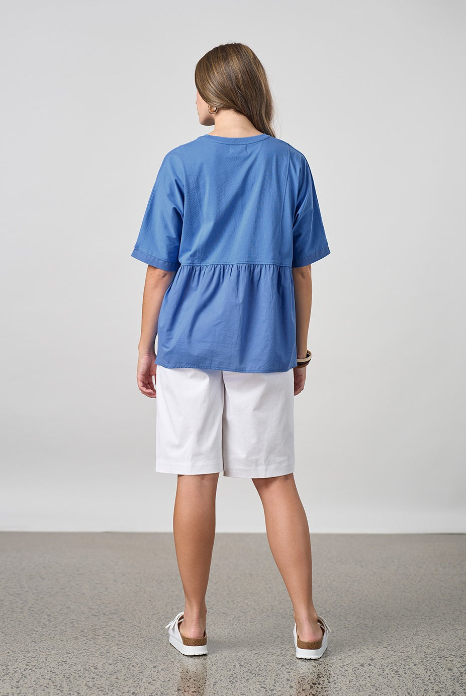 blue shirt with white short worn by model back view