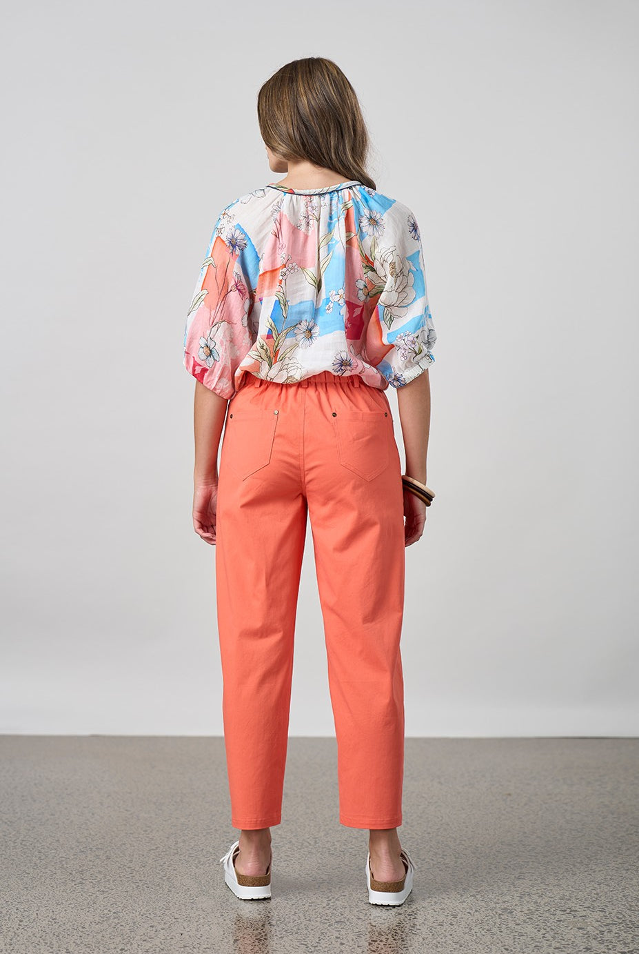 womens orange tulip pant and floral top worn by model back view