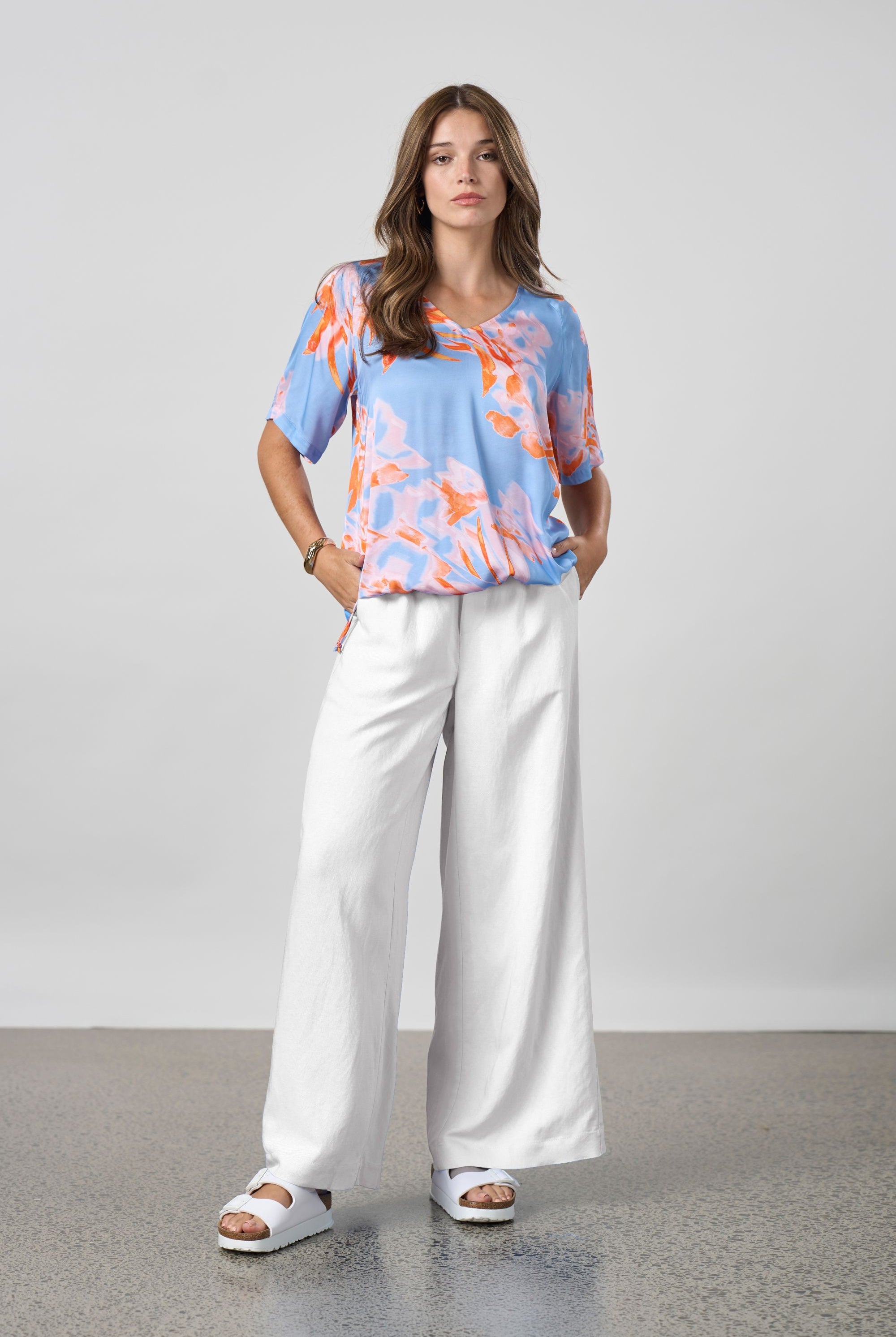 blue with coral floral top worn by model with white pants