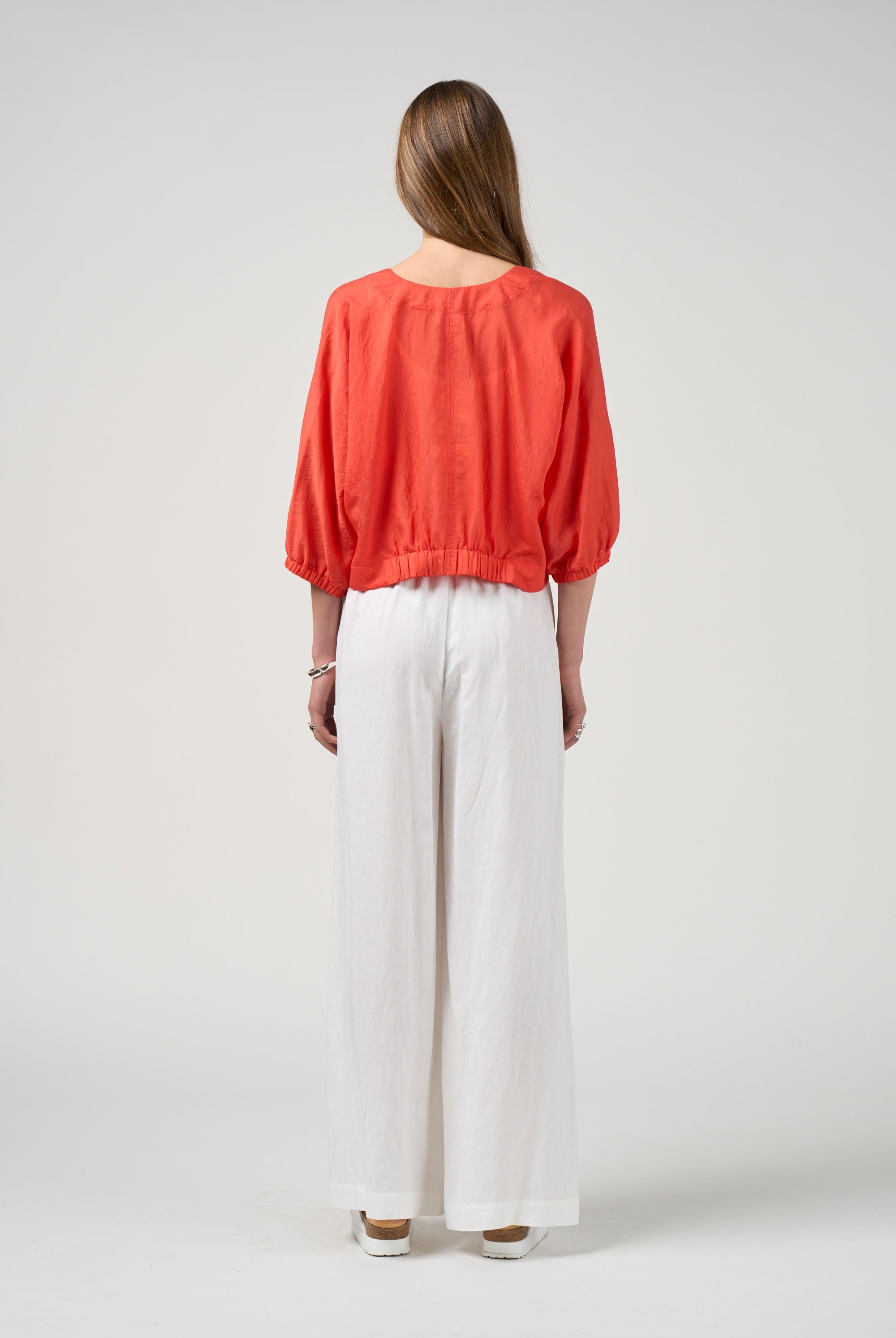 orange tie jacket with white pant worn by model back view