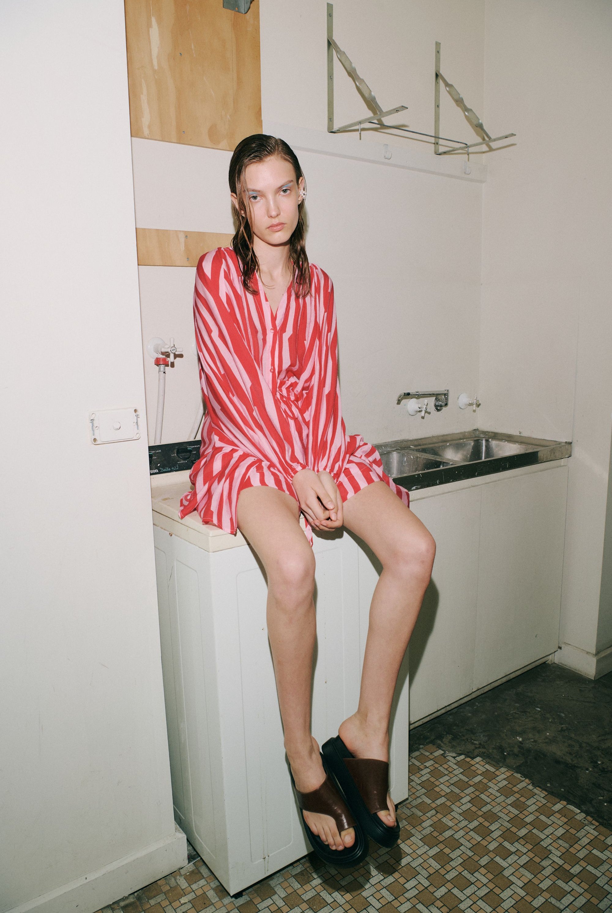 red pink stripe short dress shirt worn by model in bathroom