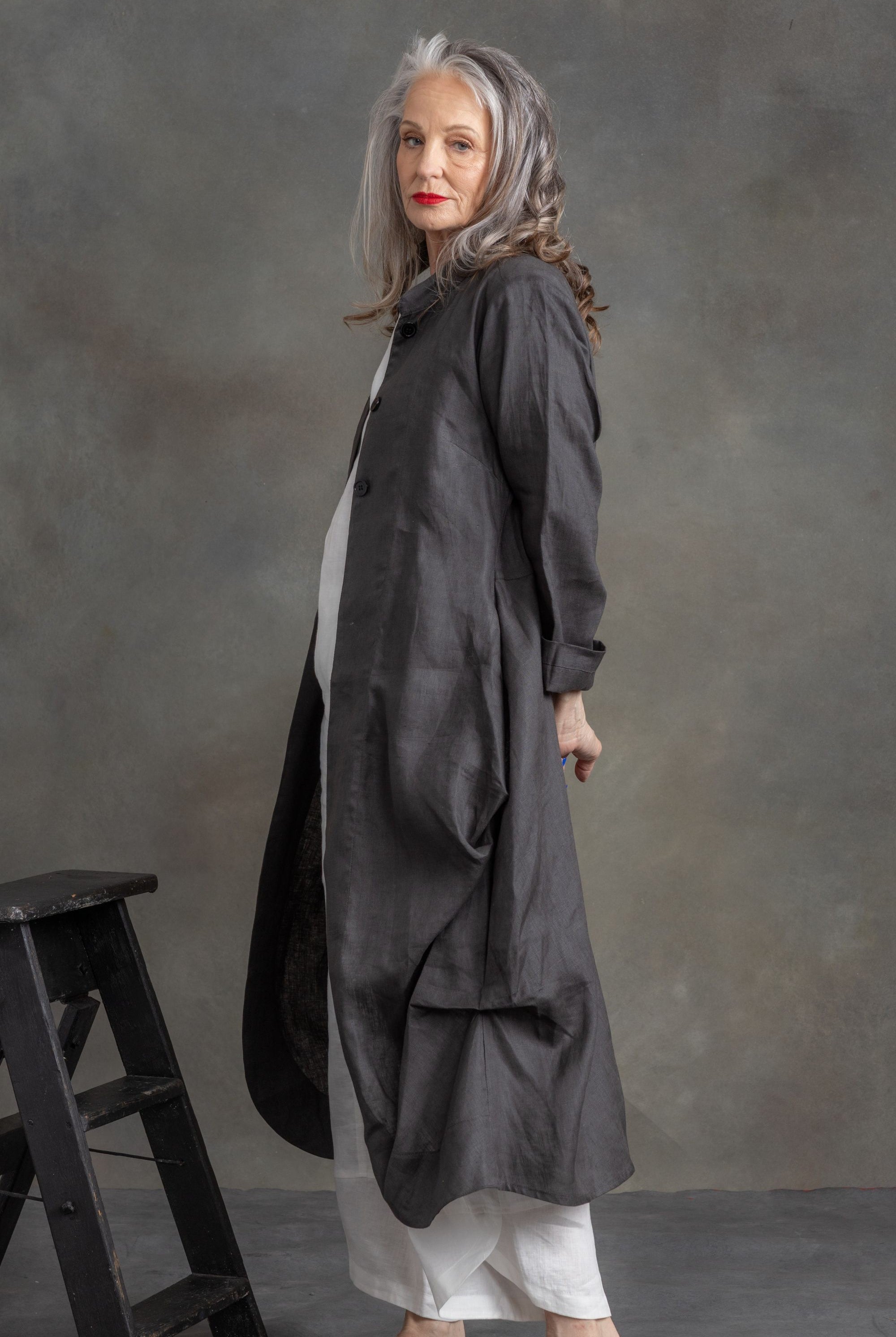 model wearing charcoal linen longline coat in front of grey background
