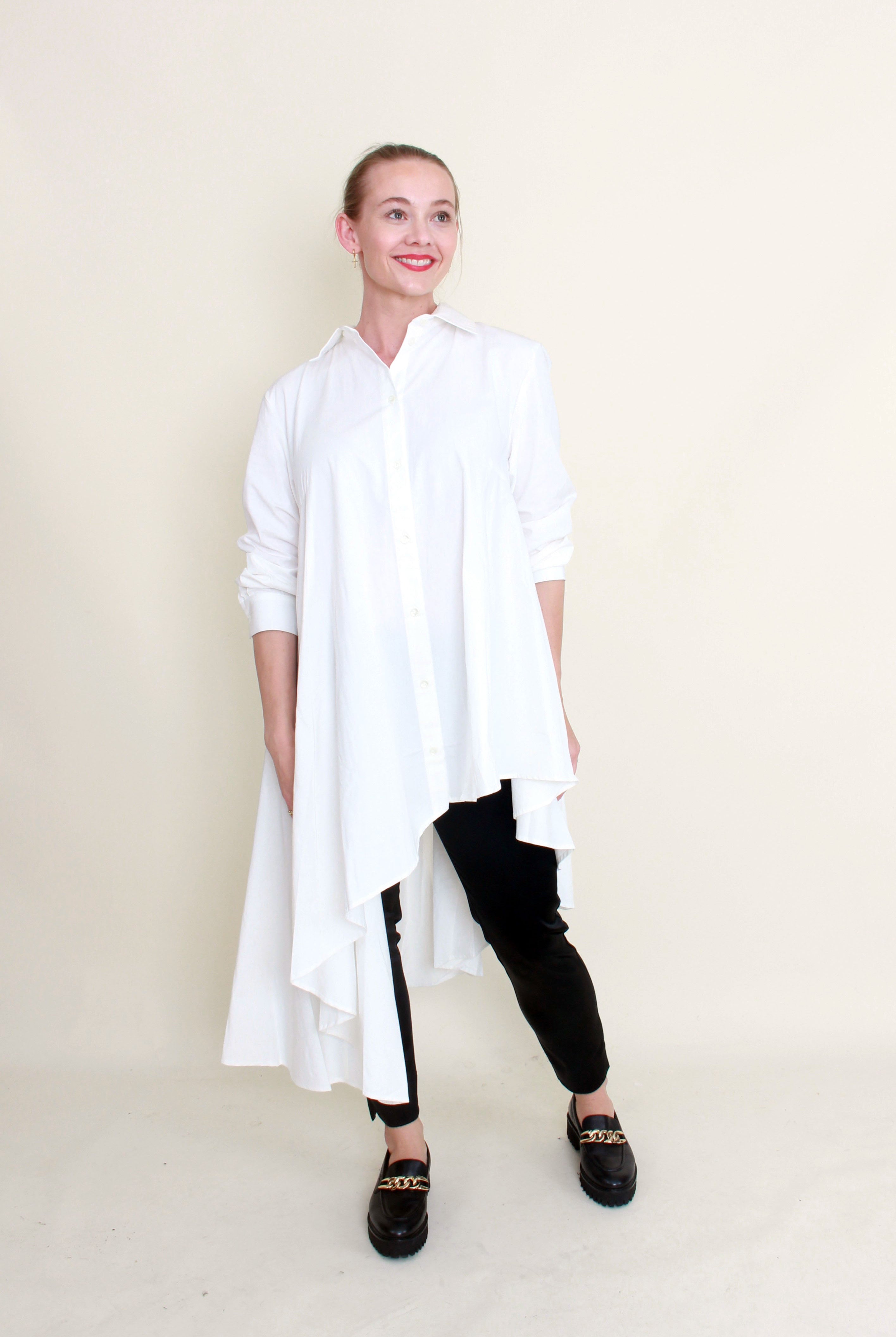 A model wearing a white shirt and black slim leg pants with a flat pull-on waistband and side splits.