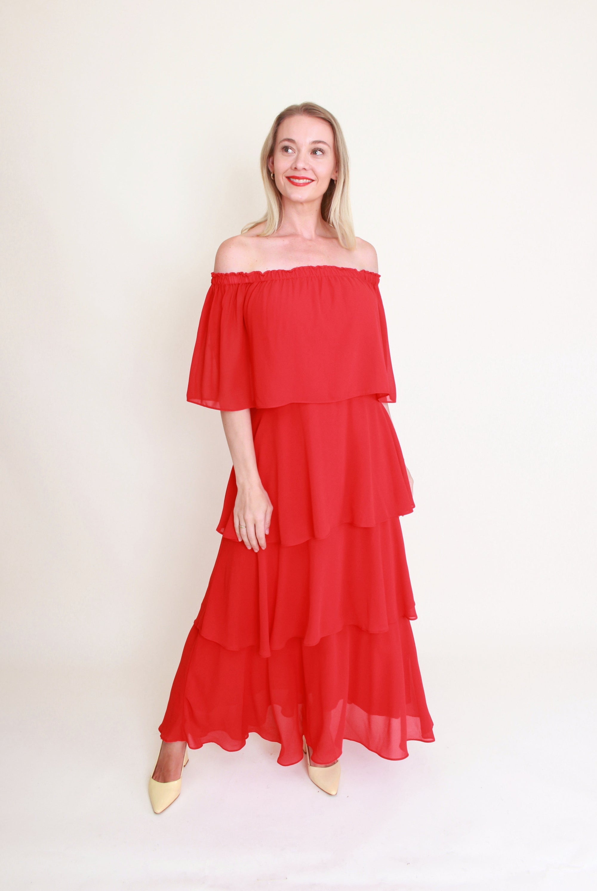 woman wearing red tiered dress against white background