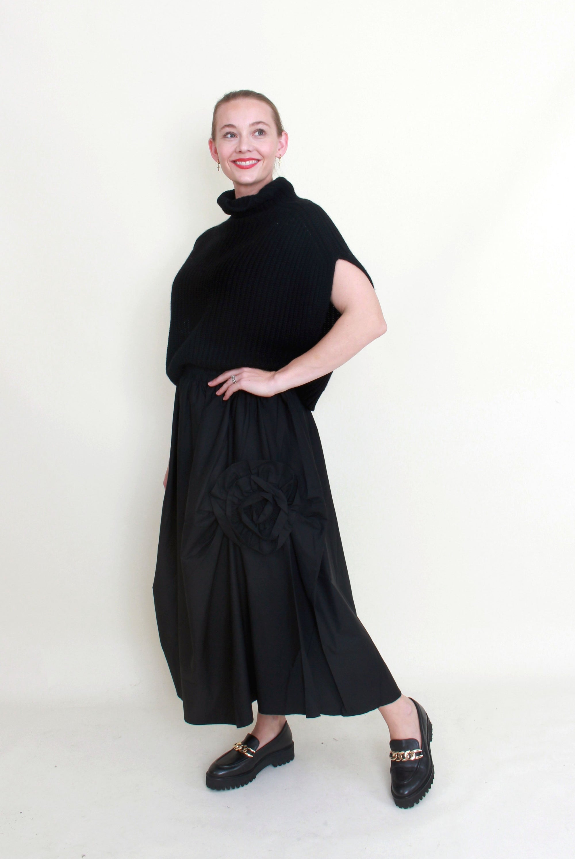black maxi skirt rosette detail with black knit top worn by model