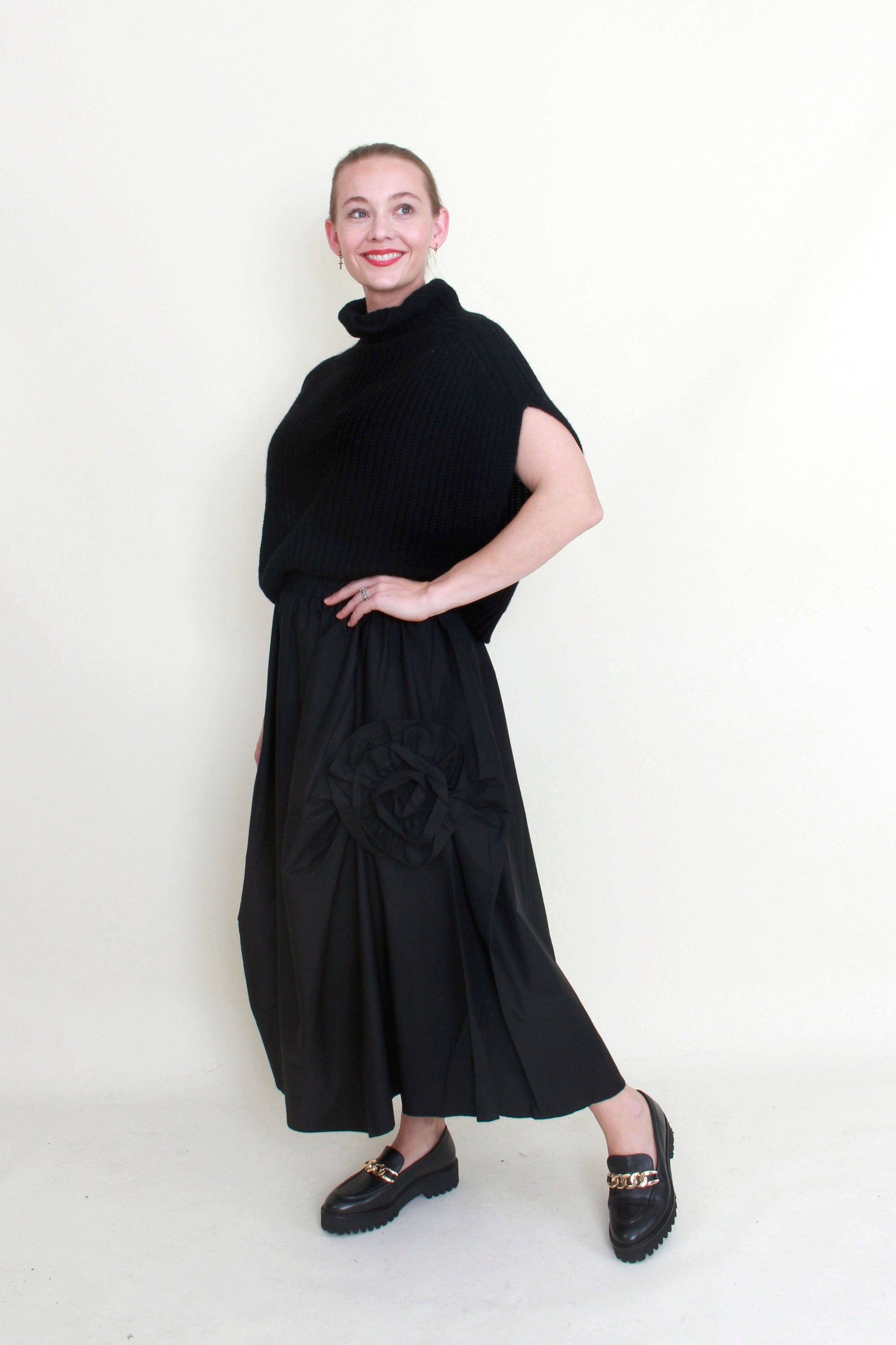 black maxi skirt rosette detail with black knit top worn by model
