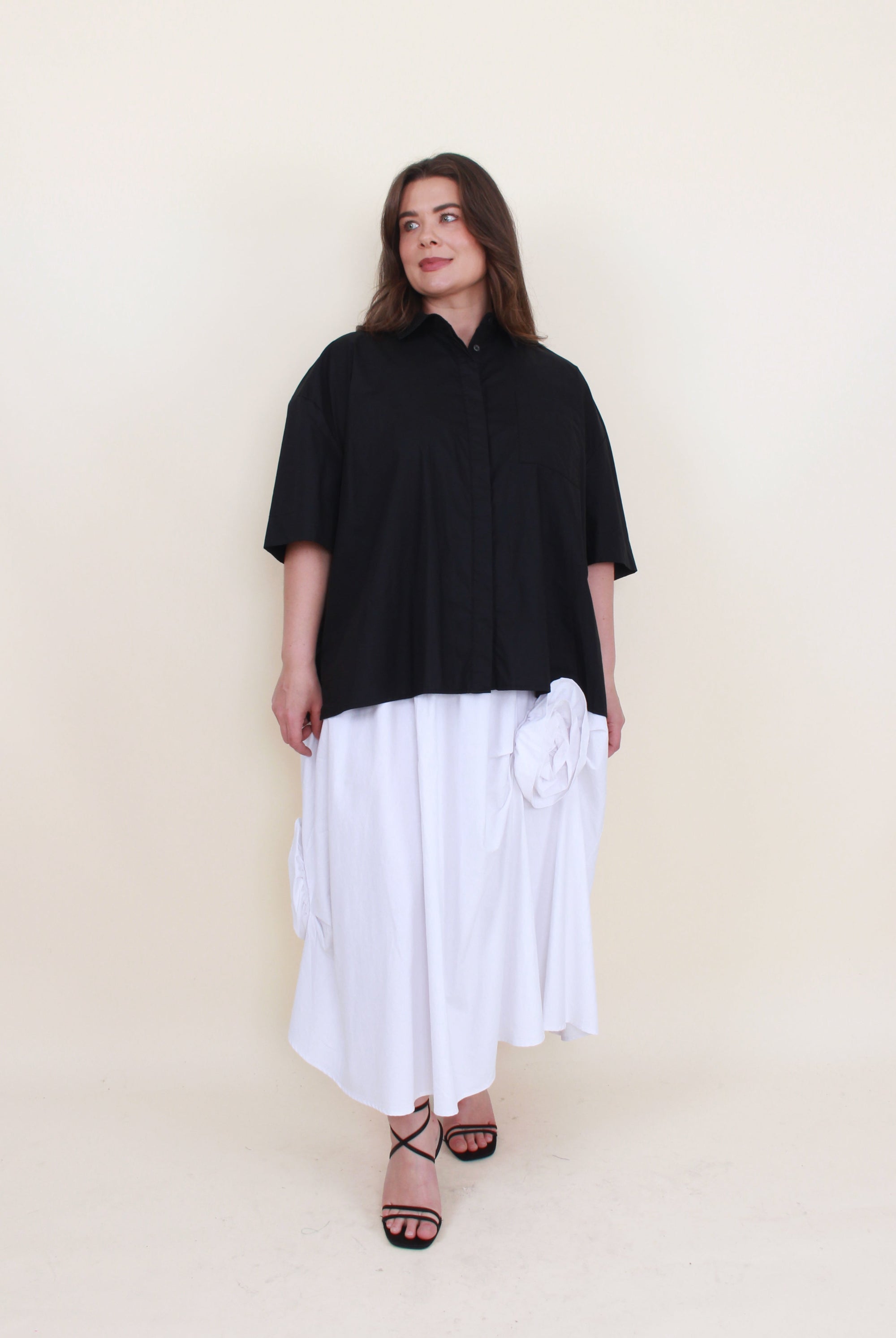 white maxi skirt with rosette appliques and black shirt worn by model