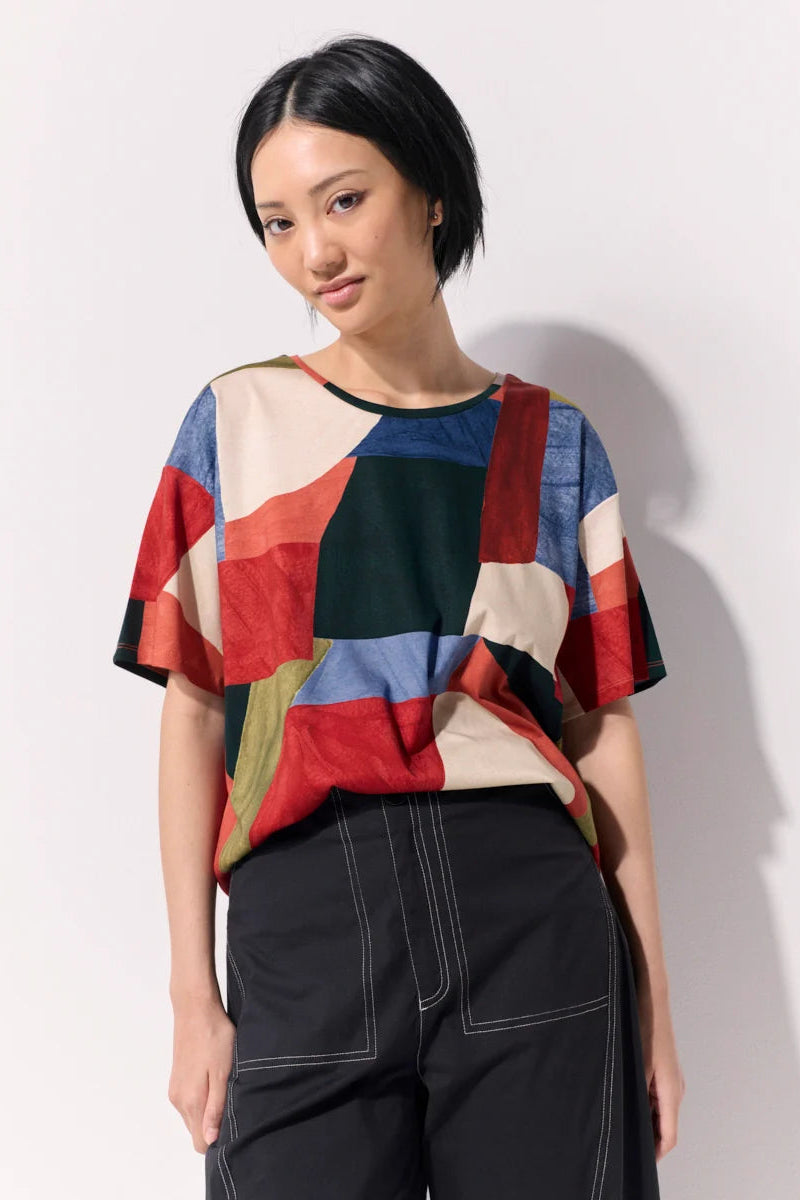 Model wearing an abstract print tee shirt against a white background