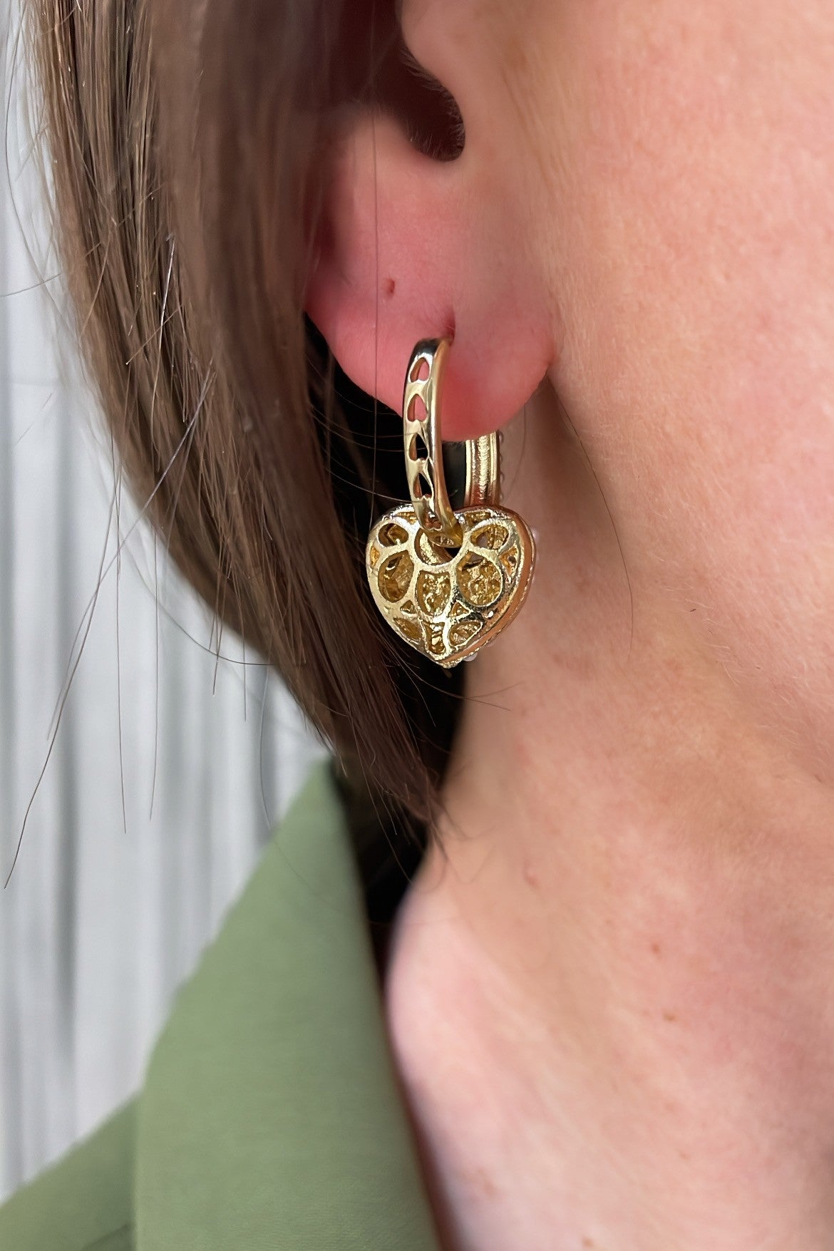 gold heart charm hoop earrings with pearl details on ear