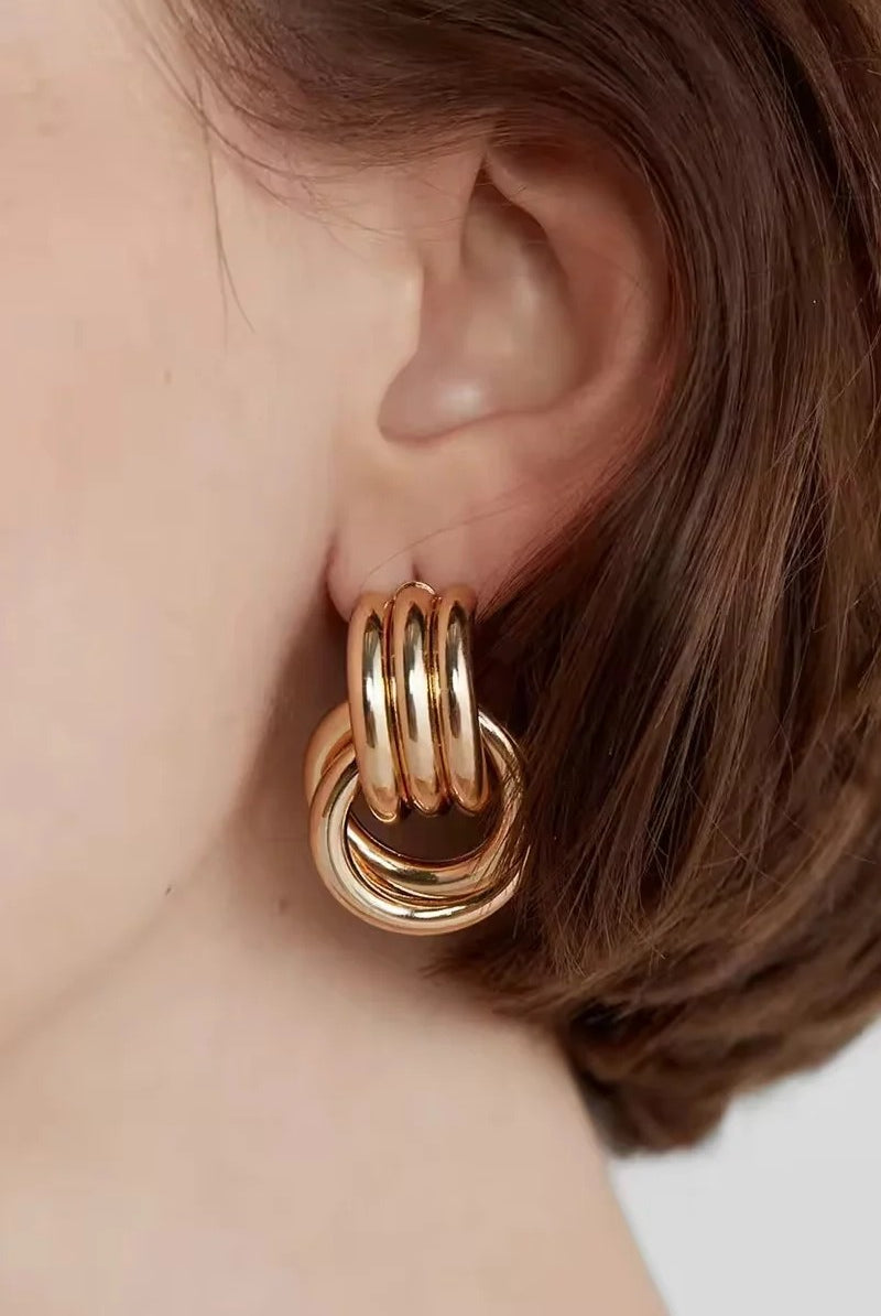 Gold loop drop hoop earring on ear