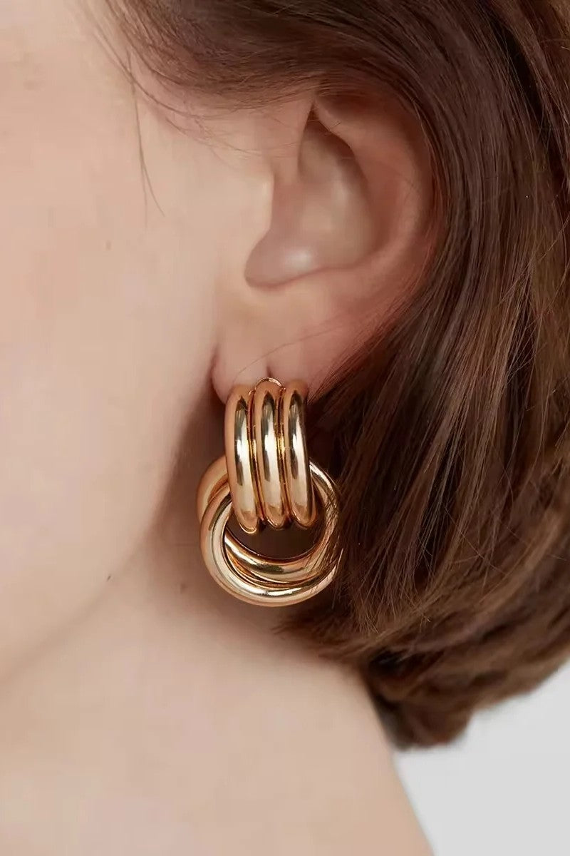 Gold loop drop hoop earring on ear