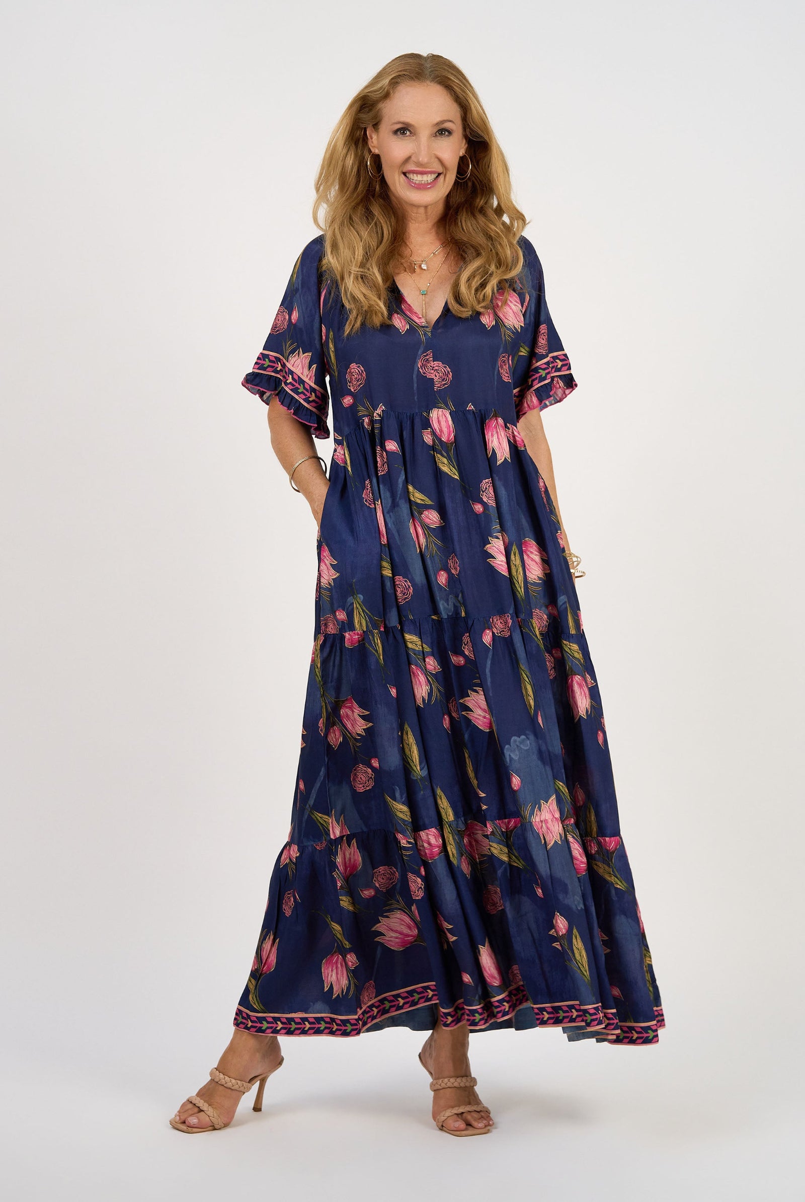 Woman wearing a navy floral dress on a white background