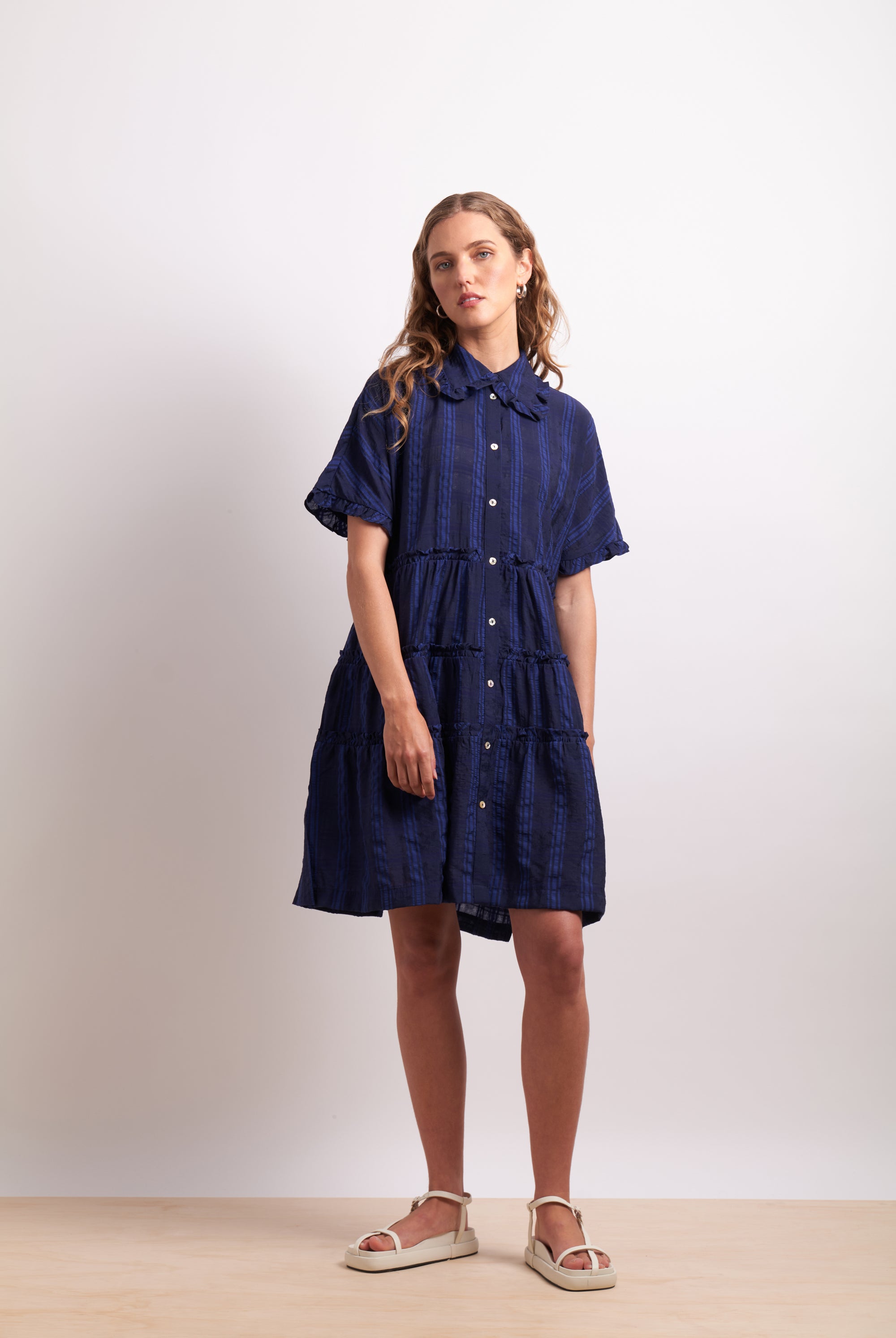 Woman wearing a navy blue dress with a white background