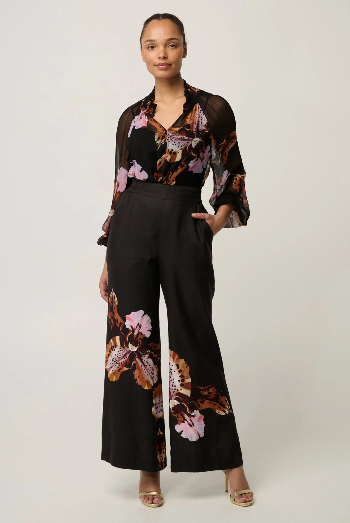 women wearing a black blouse with floral design on a plain white background