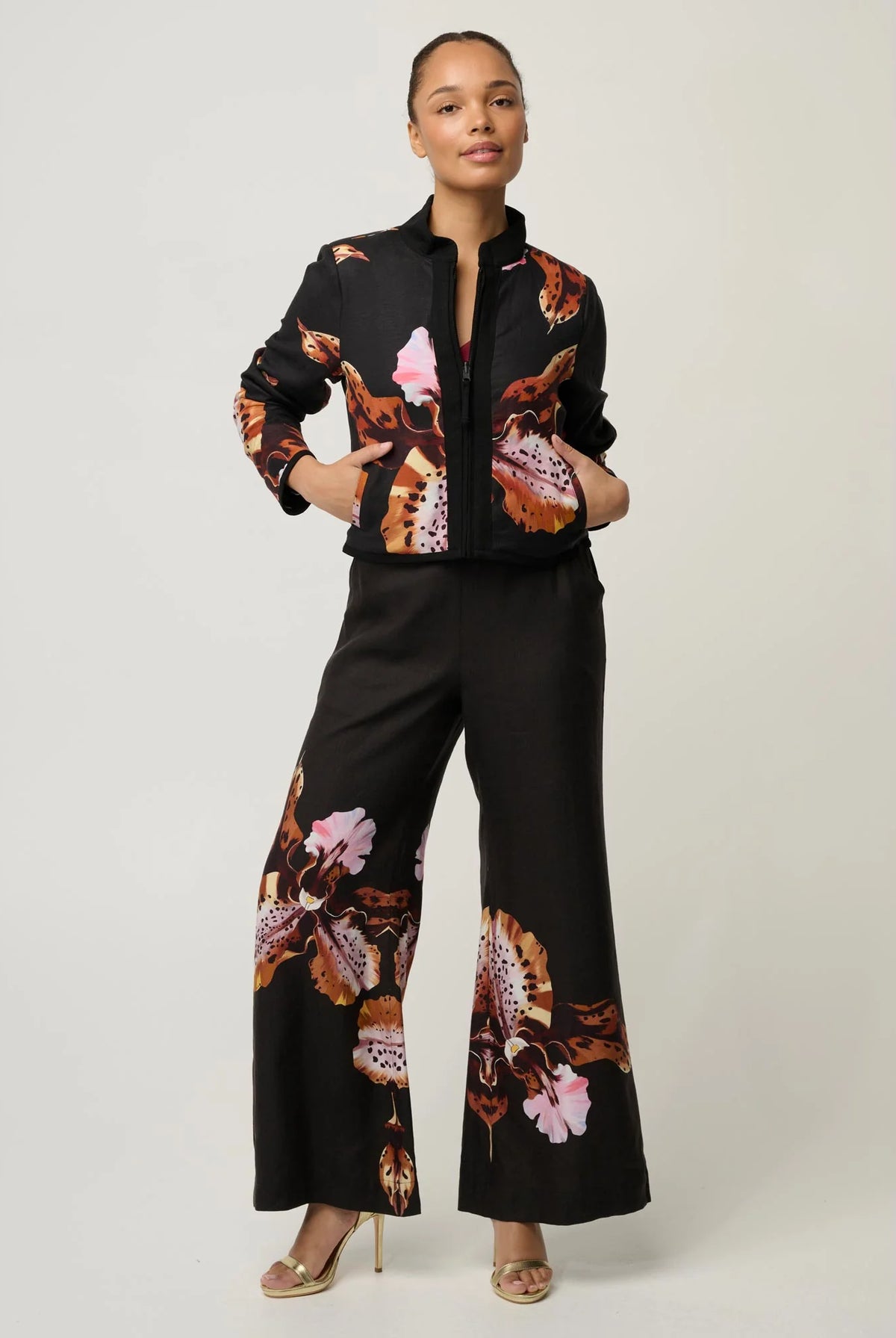 women wearing a black jacket with a floral design on a plain background