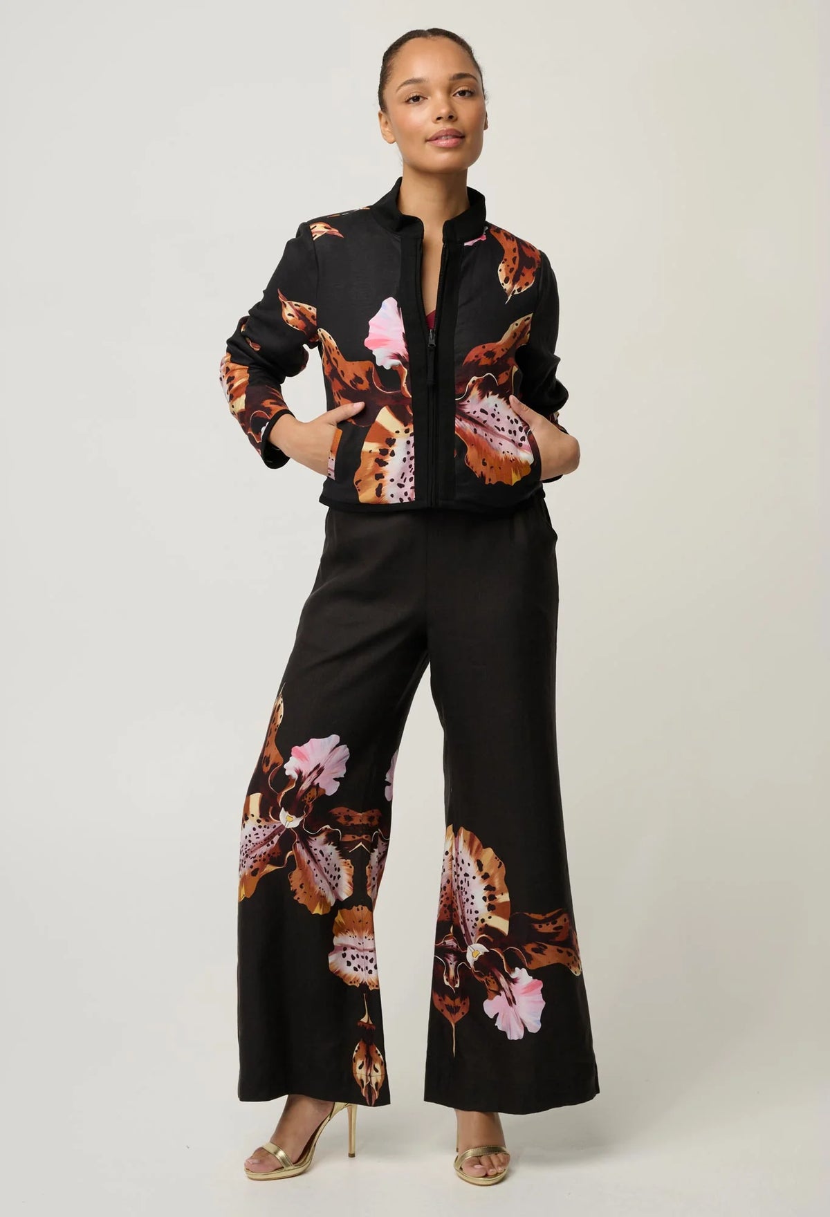 women wearing a black jacket with a floral design on a plain background