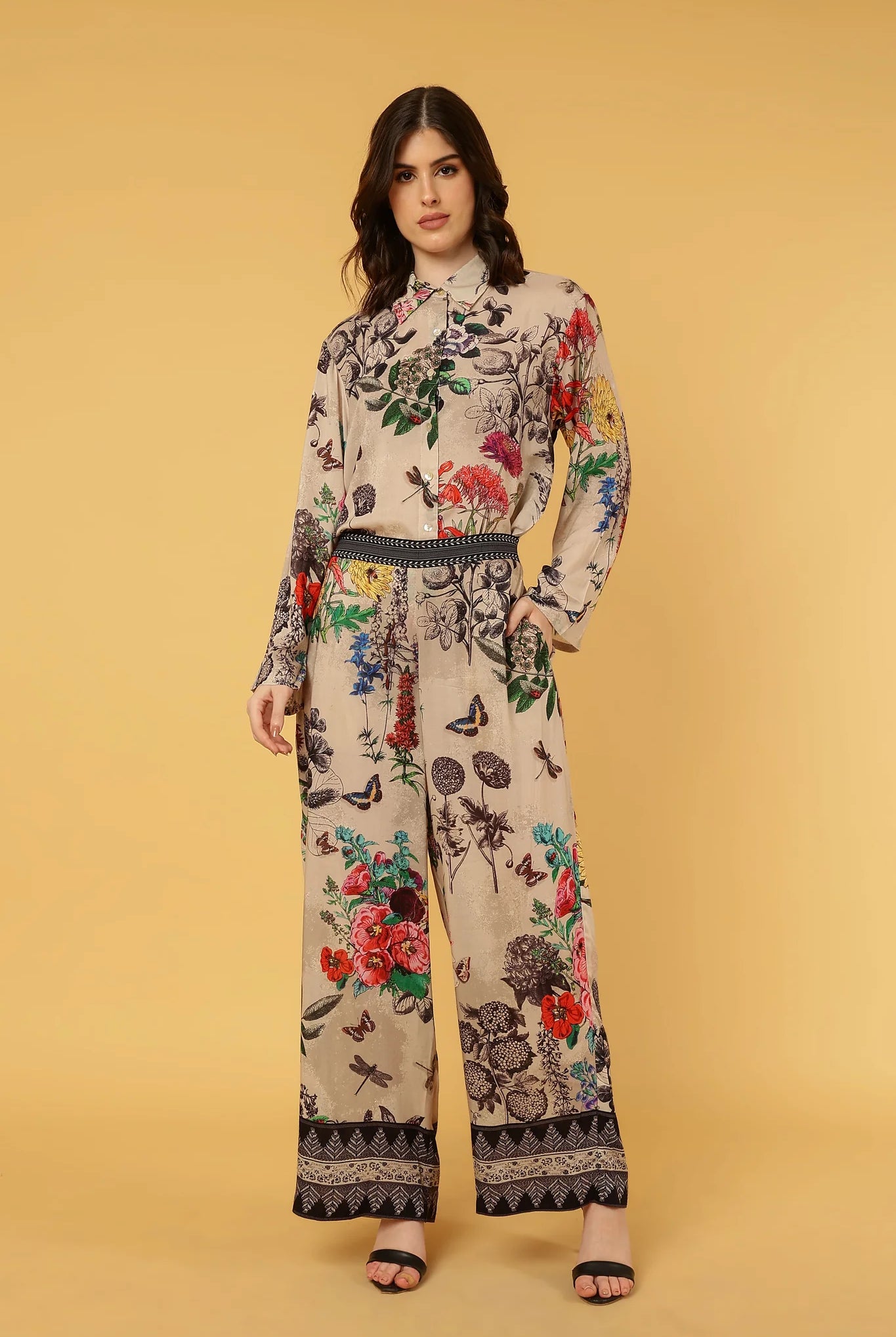 women wearing floral and butterfly pattern pants and shirt on yellow background