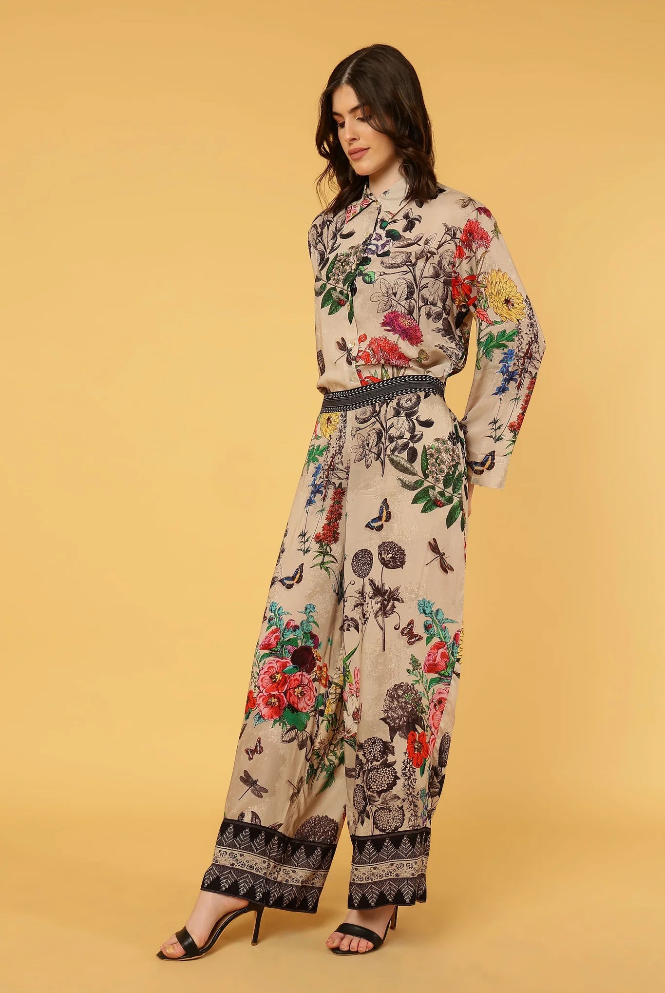 women wearing floral and butterfly pattern pants and shirt on yellow background