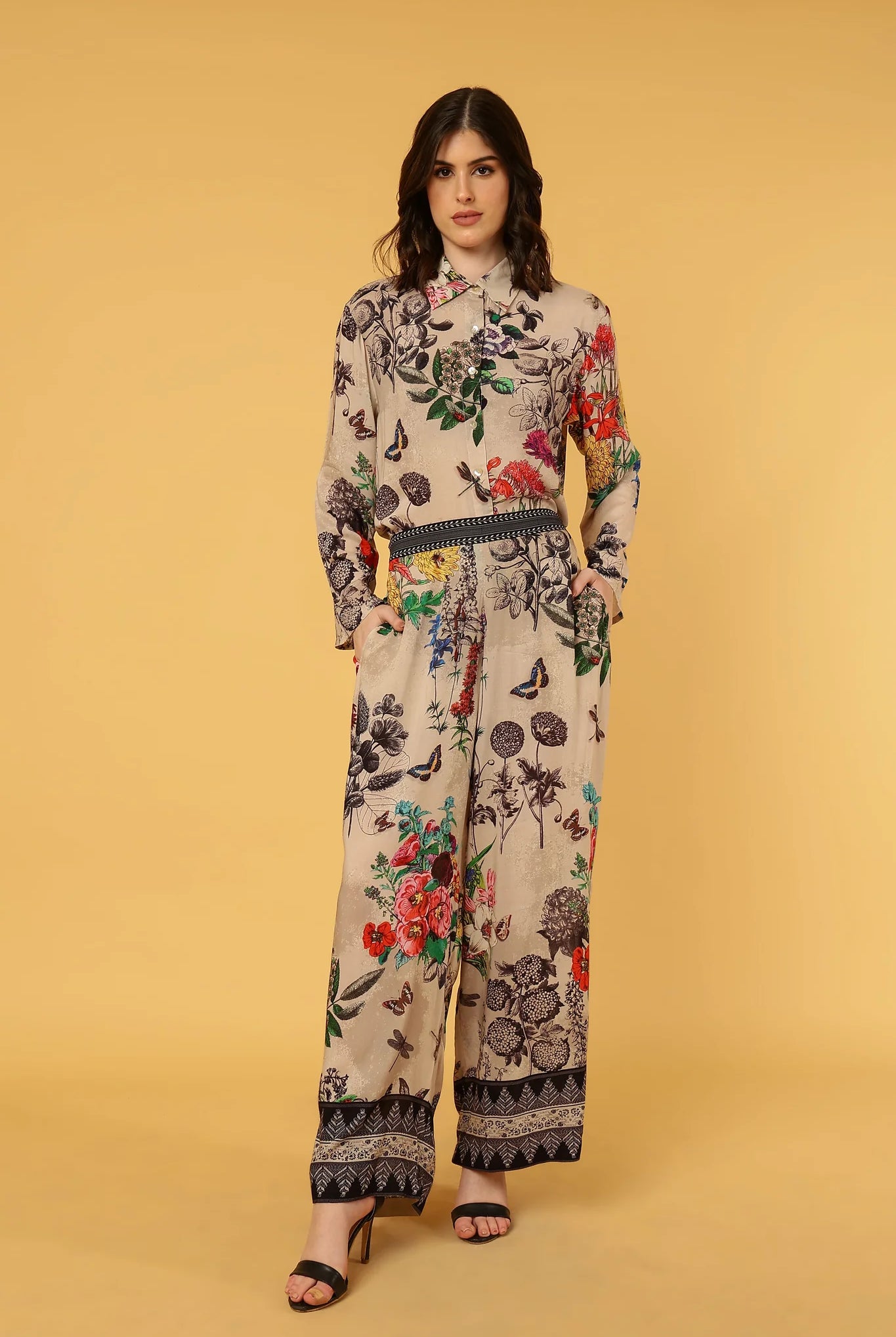 Woman wearing a floral patterned outfit on a beige background