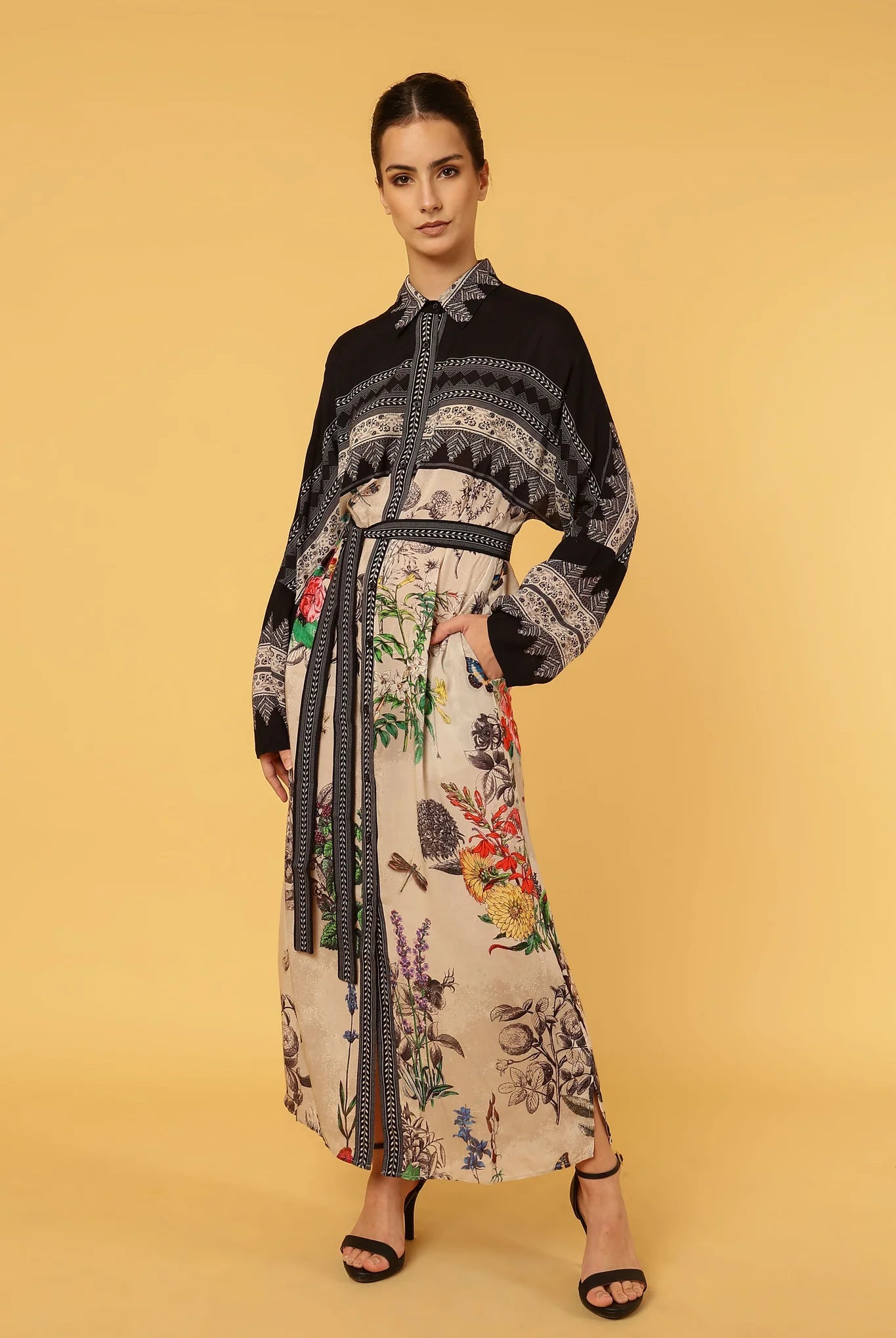 Woman wearing a floral dress with a black pattern on a yellow background
