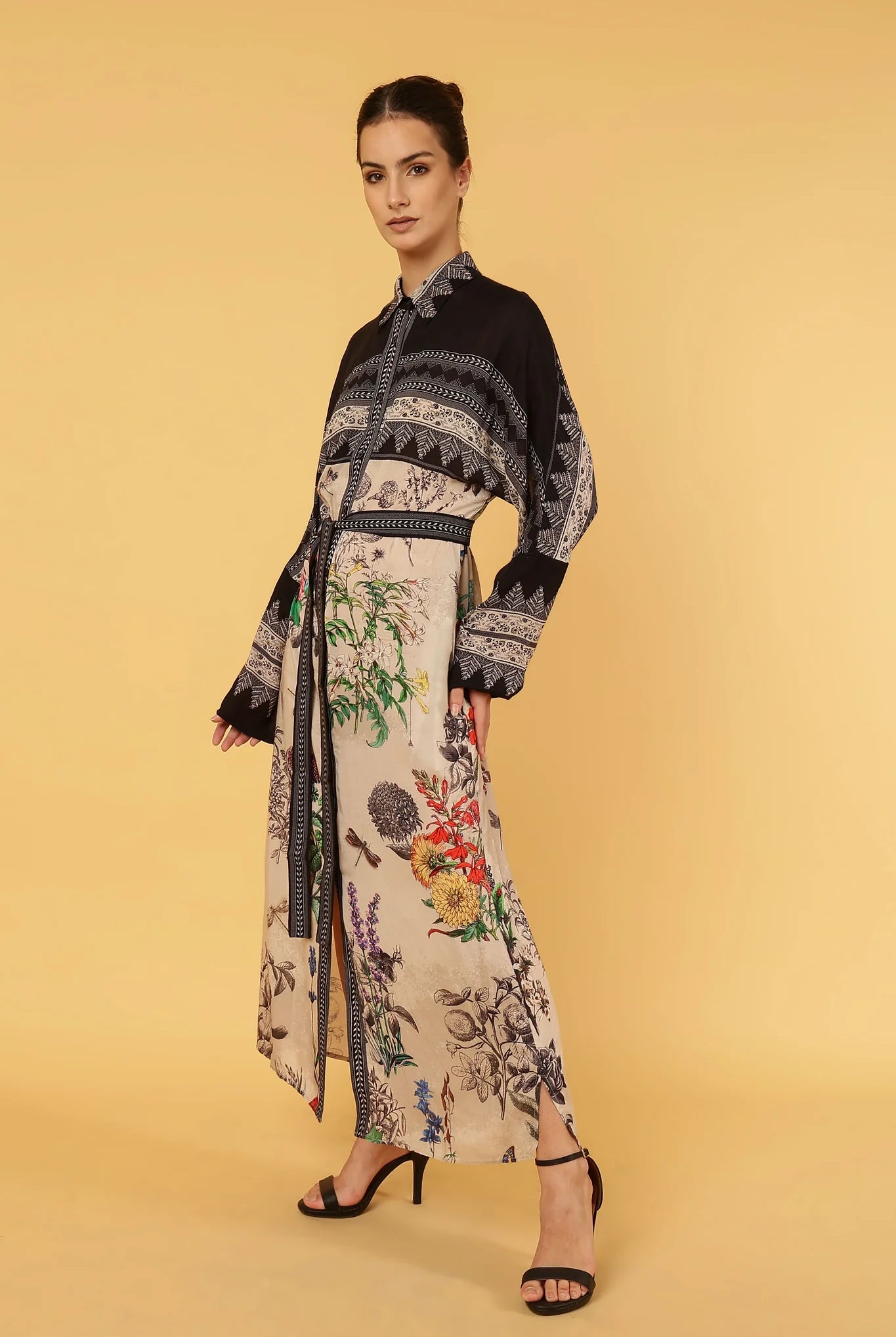 Woman wearing a floral dress with a black pattern on a yellow background