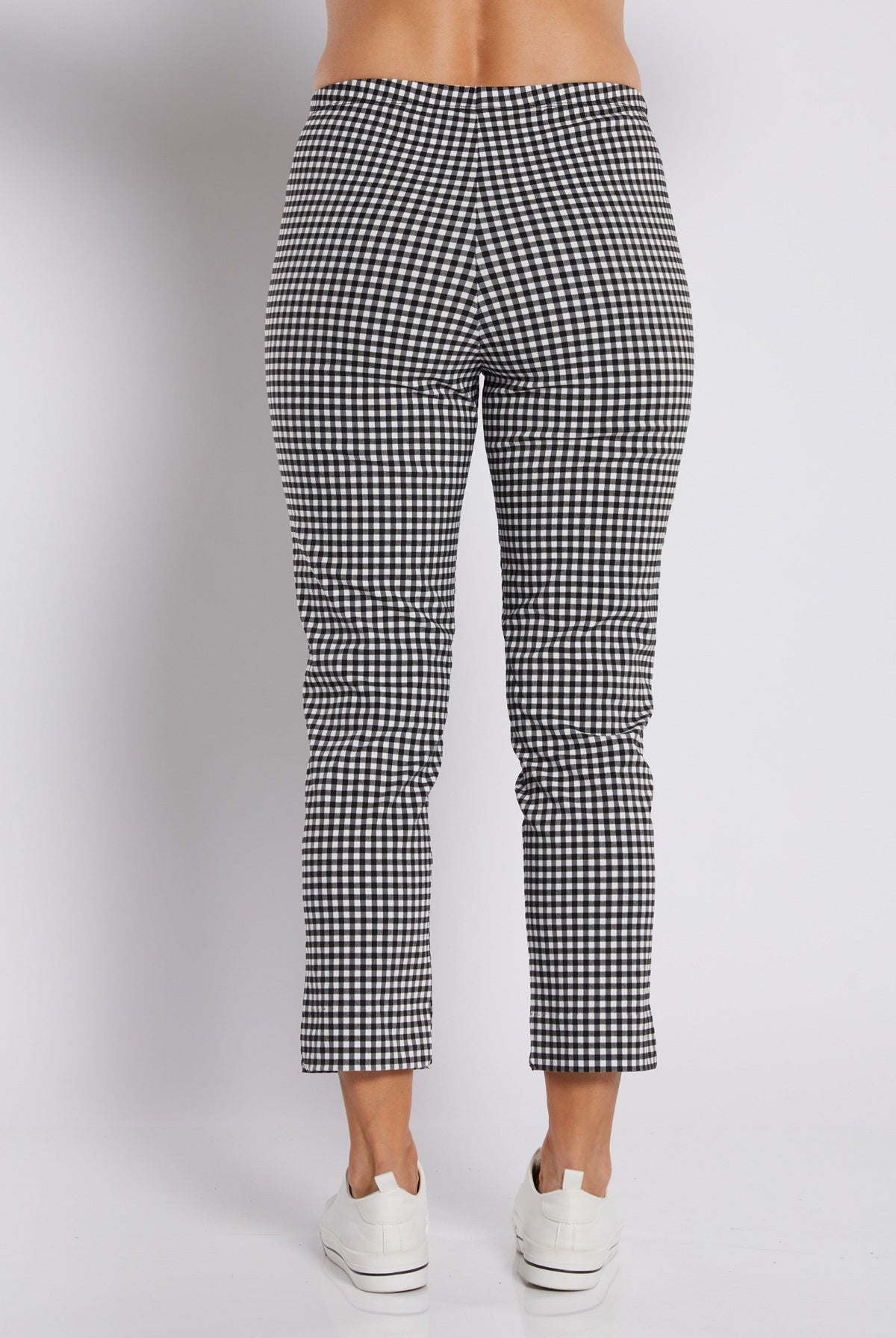 Black and white gingham cropped pants shown from the back on a model, paired with white sneakers against a light gray studio background.