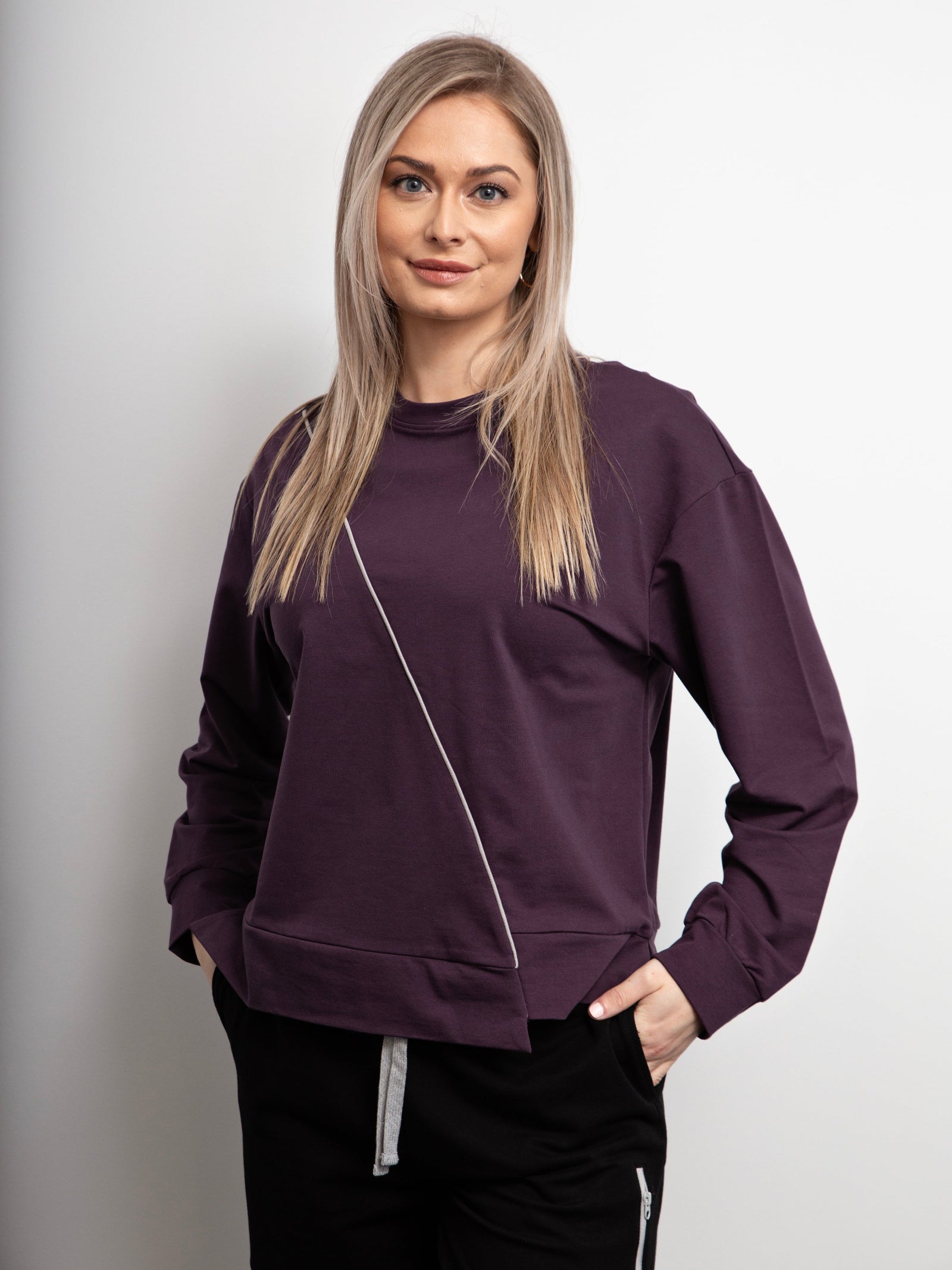 Woman wearing a purple sweatshirt with a white background
