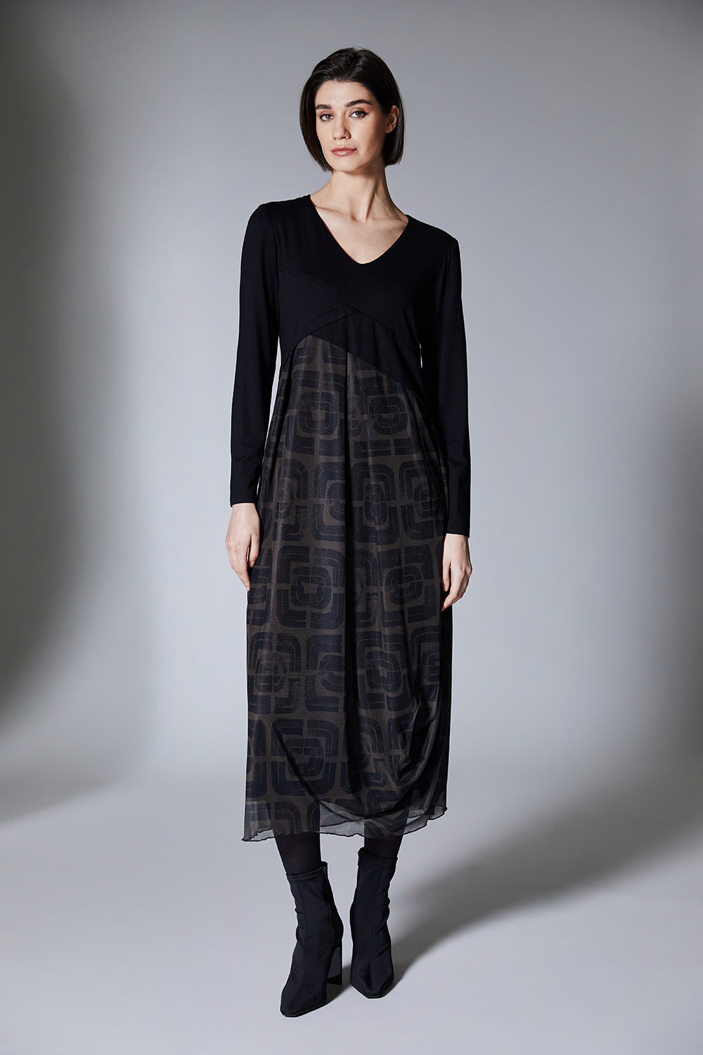Woman wearing a black and brown patterned dress on a gray background