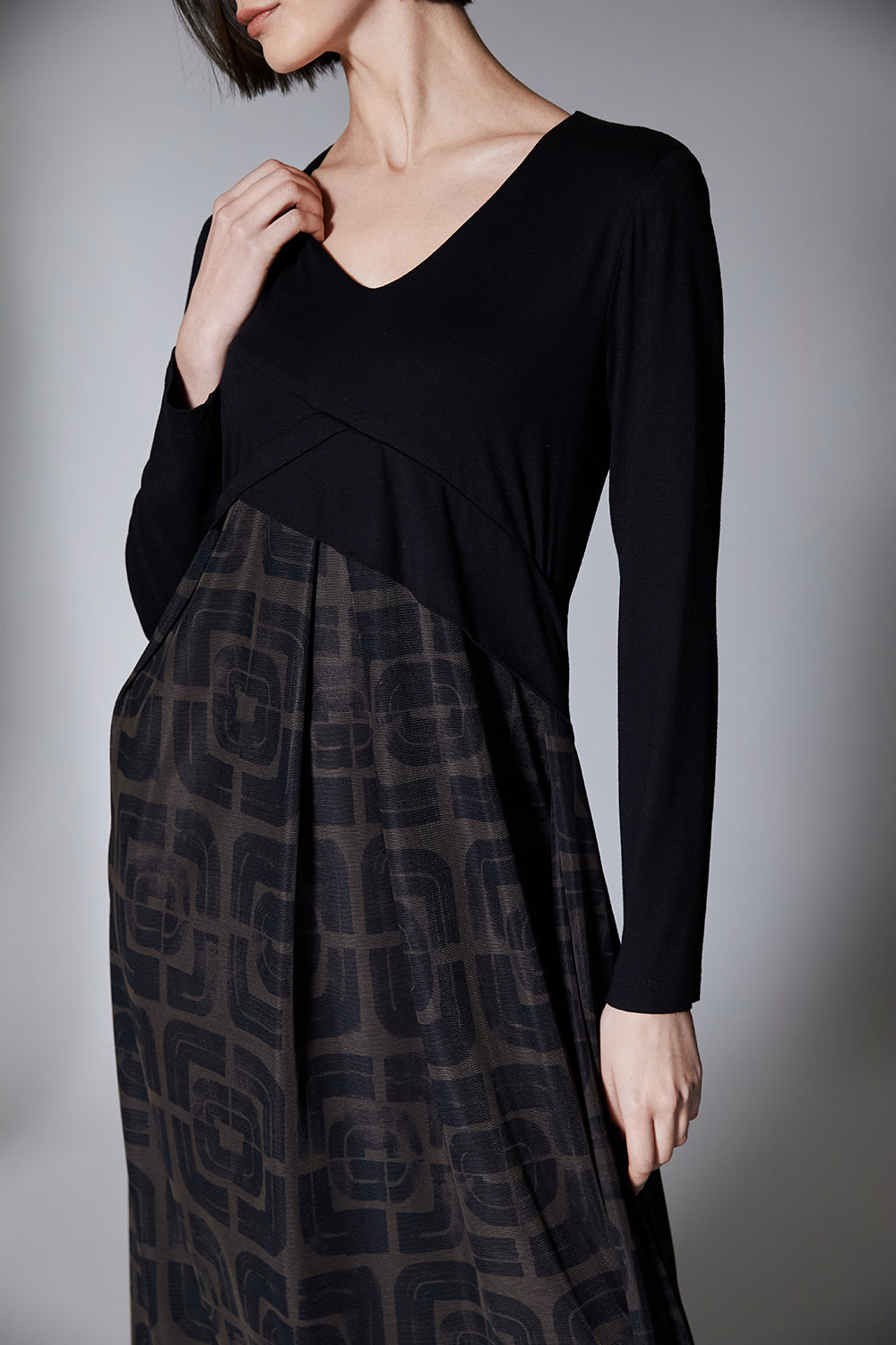 Woman wearing a black and brown patterned dress on a gray background