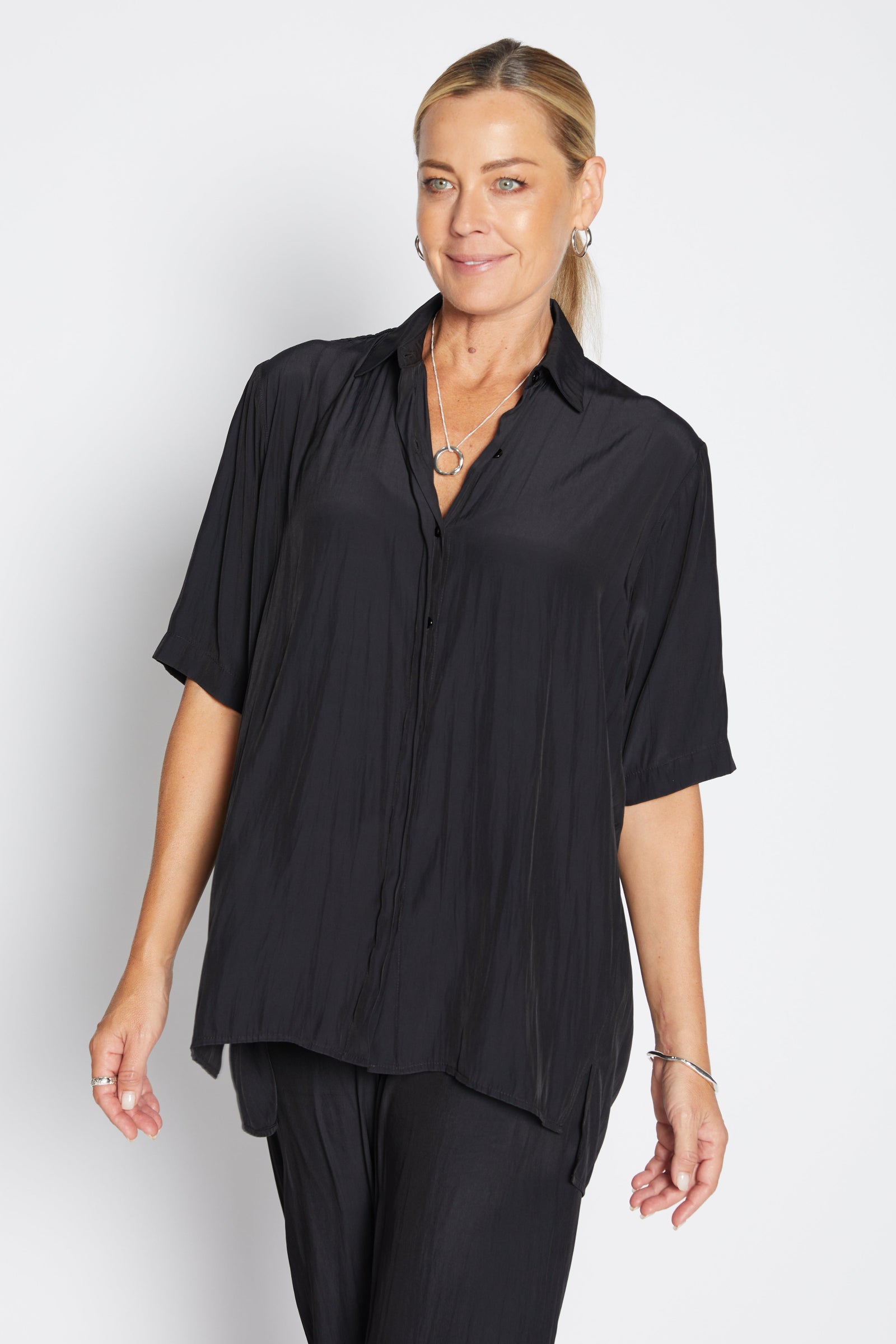 Woman wearing a black shirt and pants on a white background