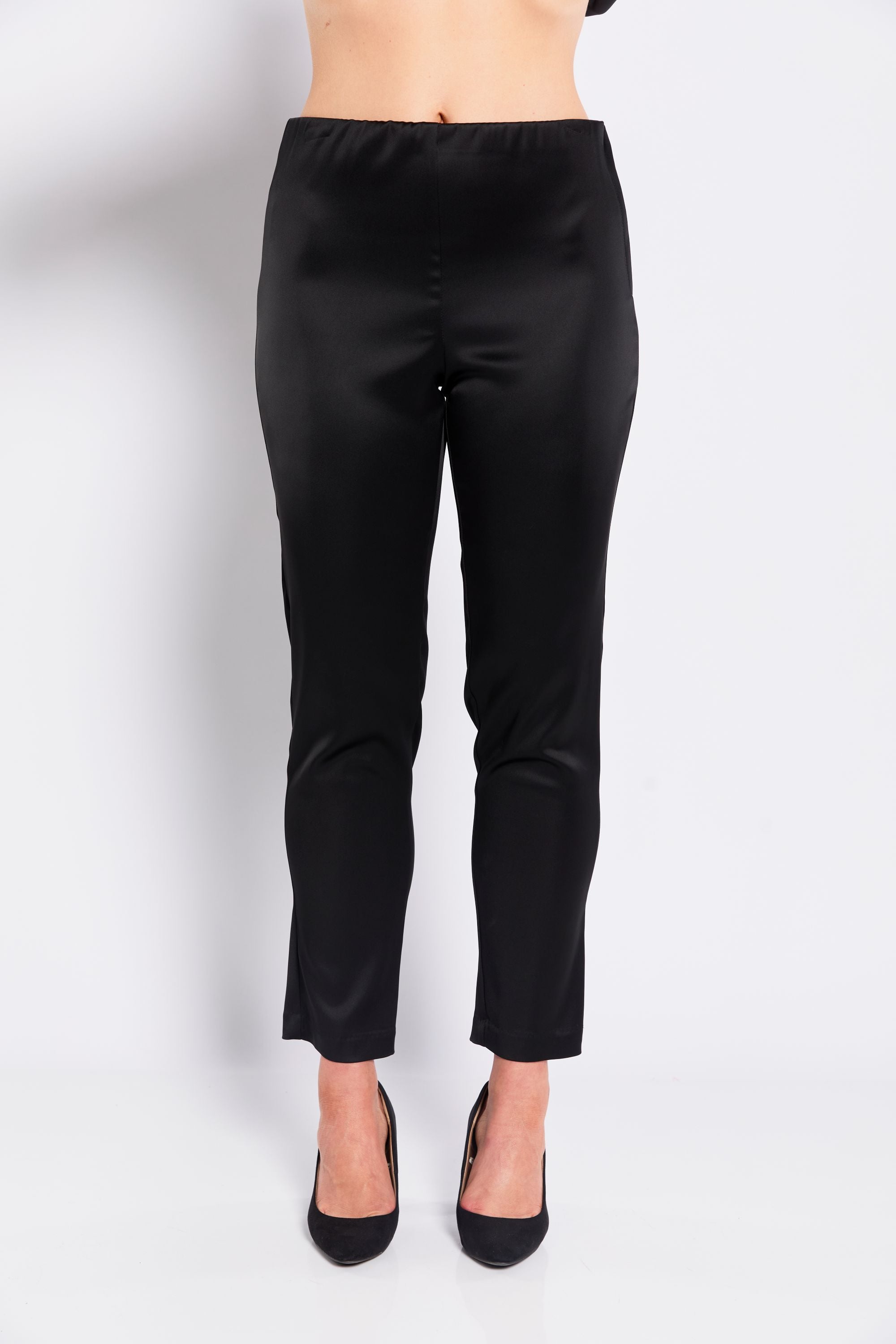 Black satin pants worn by a person on a white background