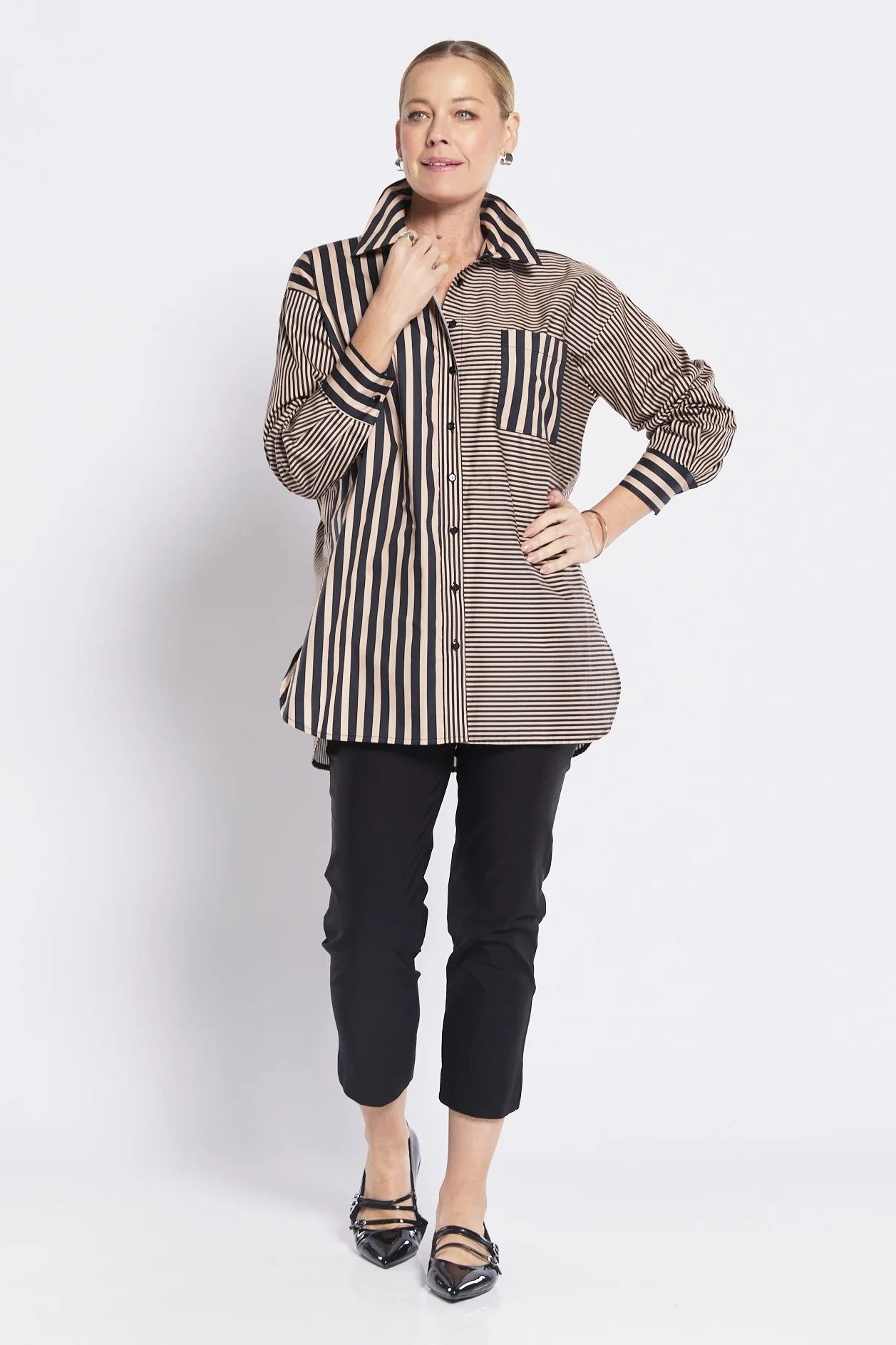 Woman wearing a striped shirt with striped sleeves on a white background