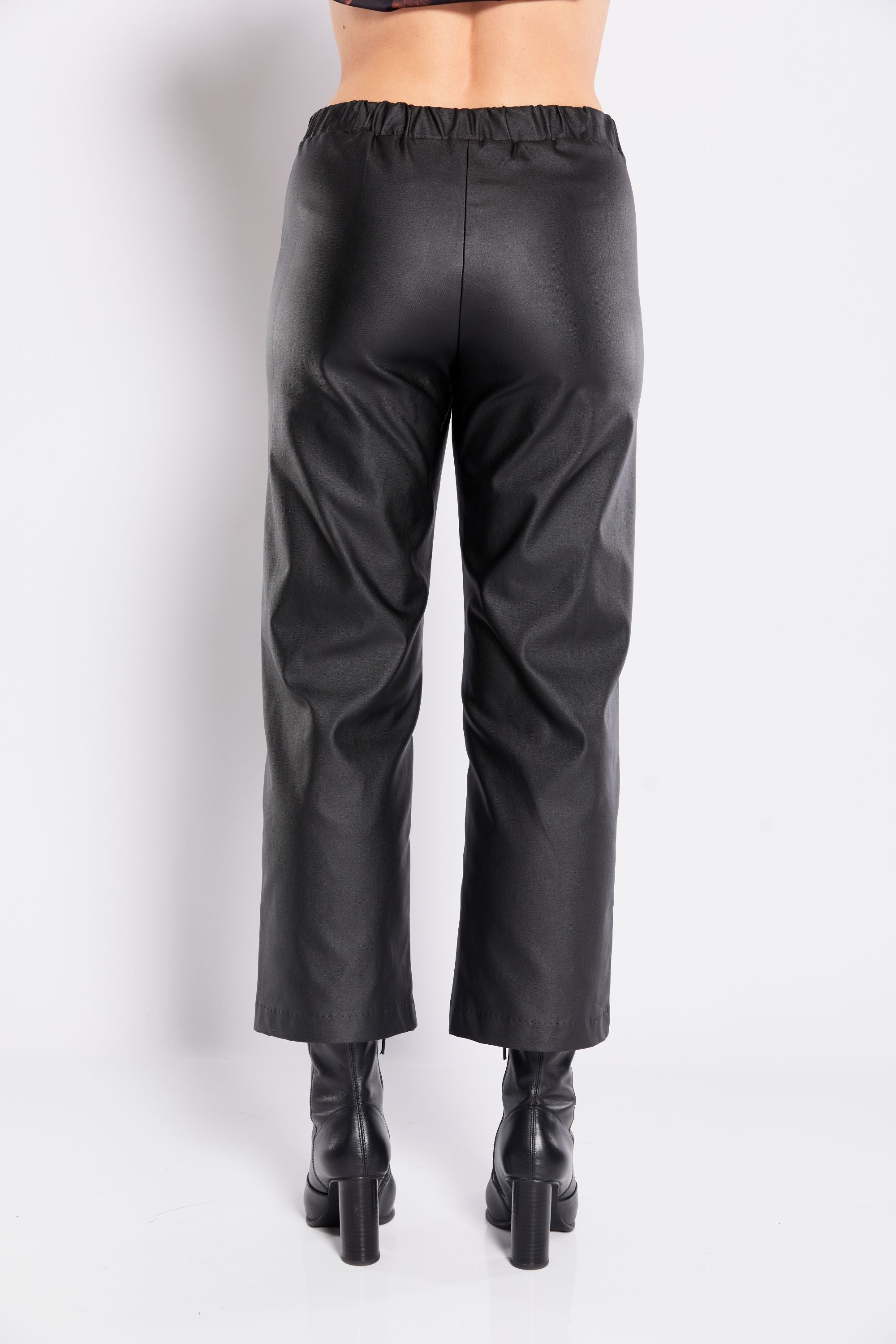 Black leather pants worn by a person on a white background back view