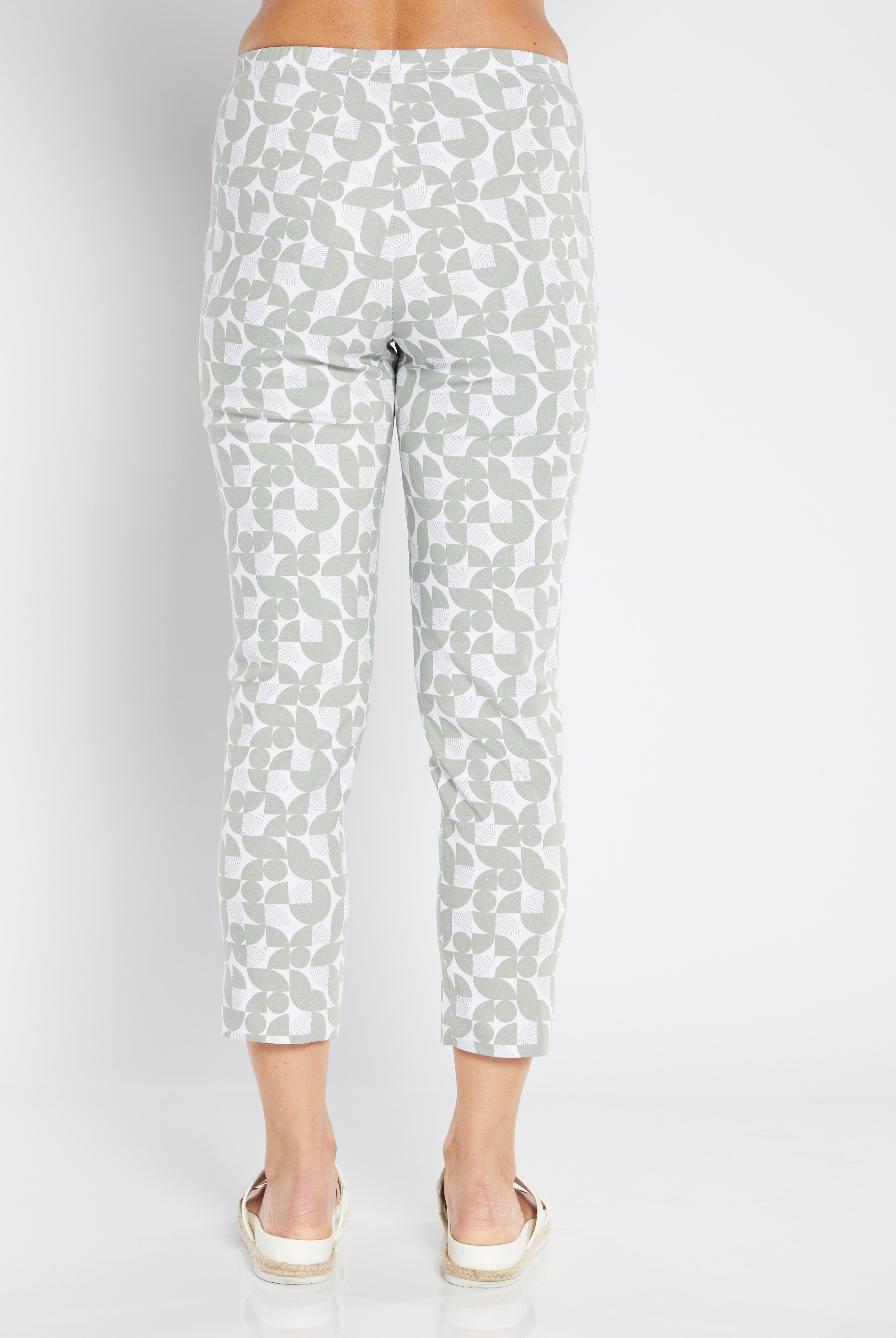 White pants with sage print pattern on a white background