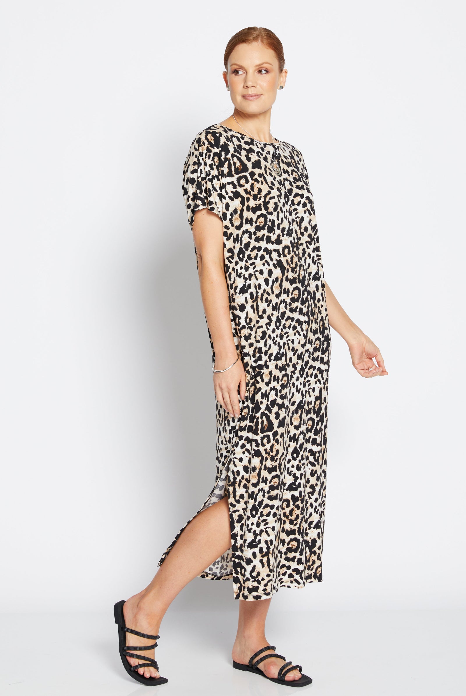 Woman wearing a leopard print dress on a white background
