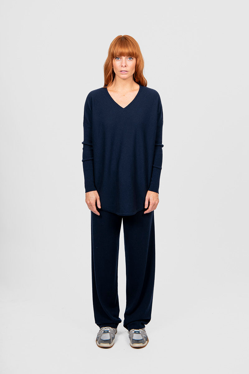 Person wearing a navy blue outfit on a white background