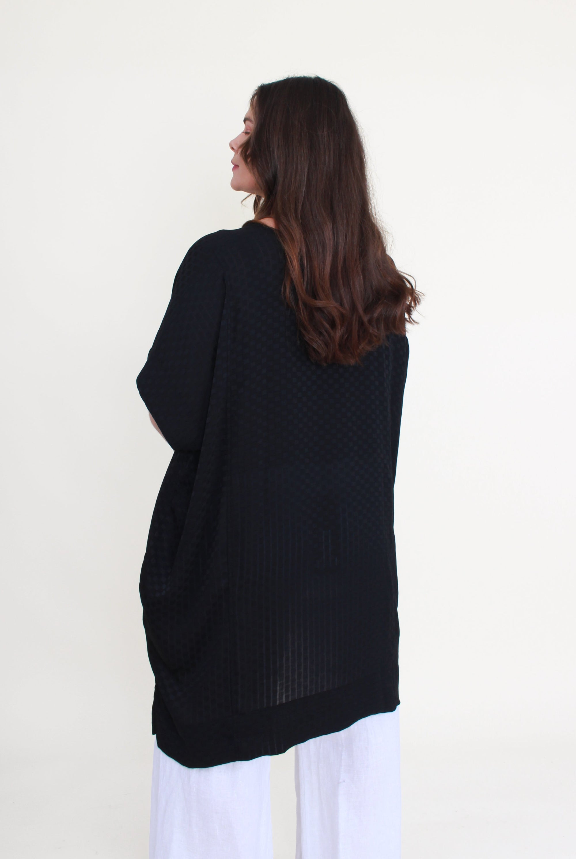 Person wearing a black top with a white background