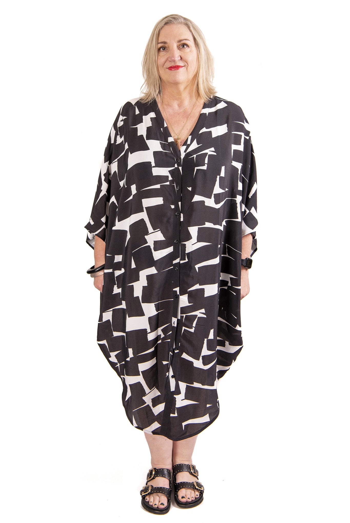 Woman wearing a black and white patterned kaftan on a white background